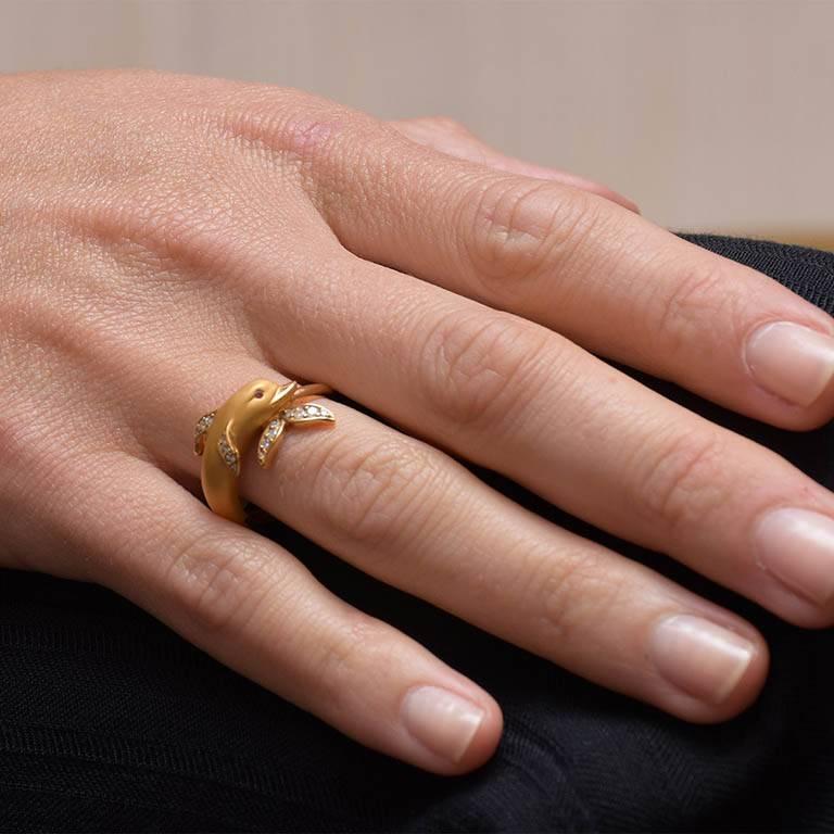 A beautifully detailed 18 karat yellow gold dolphin motif ring accented with 0.12 carats of diamonds. Made by Carrera y Carrera, expert jewelers based in Madrid, Spain. The ring features both high polished and in typical Carrera y Carrera fashion,