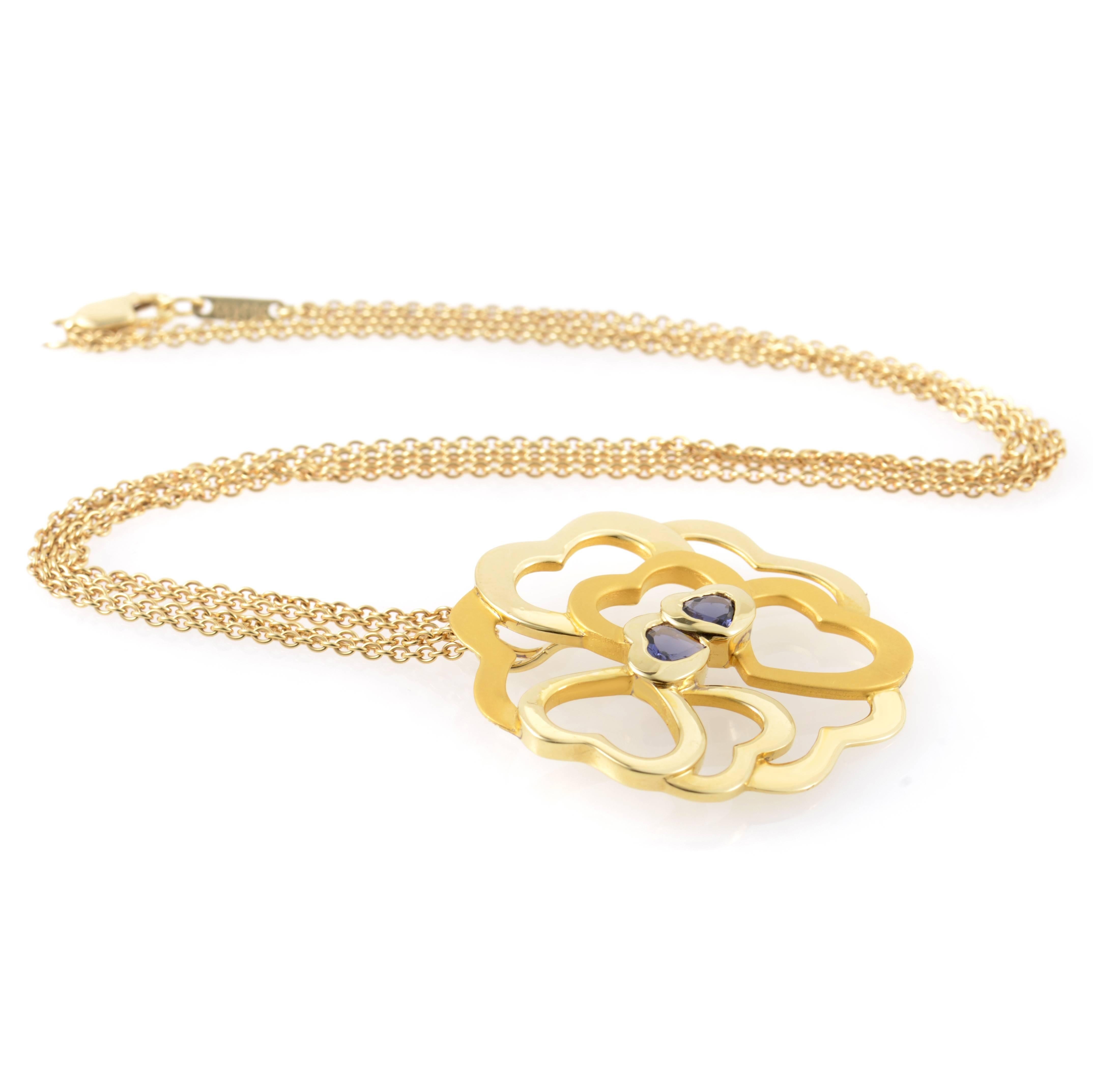 This pendant necklace from Carrera y Carrera has a festive and sumptuous design. The necklace is made of 18K yellow gold and features a pendant that depicts a cluster of hearts set with ~.64ct of iolite.