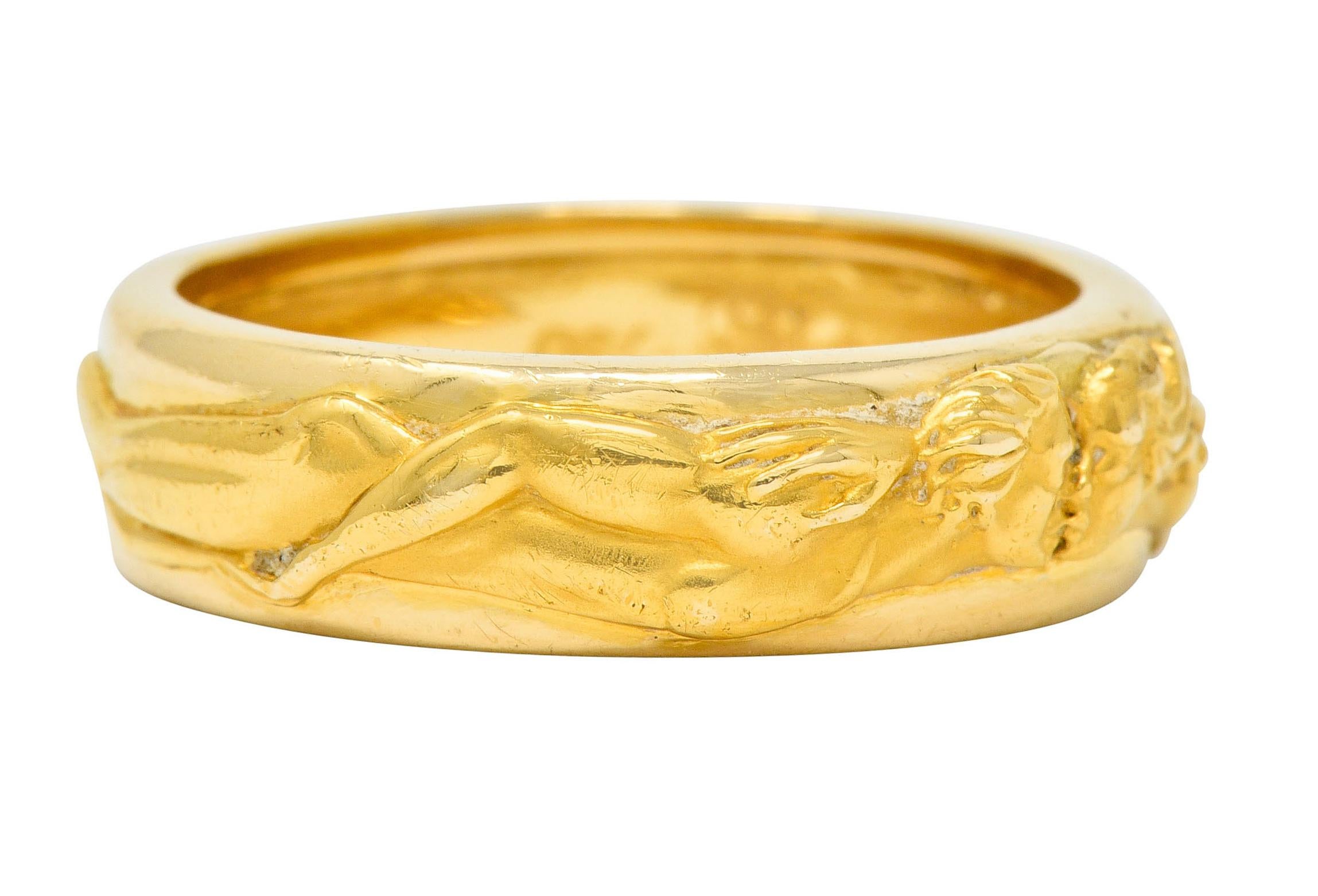 Band style ring depicting two highly rendered full-bodied figures wrapped fully around the shank, male and female

Figures are facing one another, locked in a kiss

Completed by a bright finish

With maker's mark for Carrera Y Carrera

Stamped 750