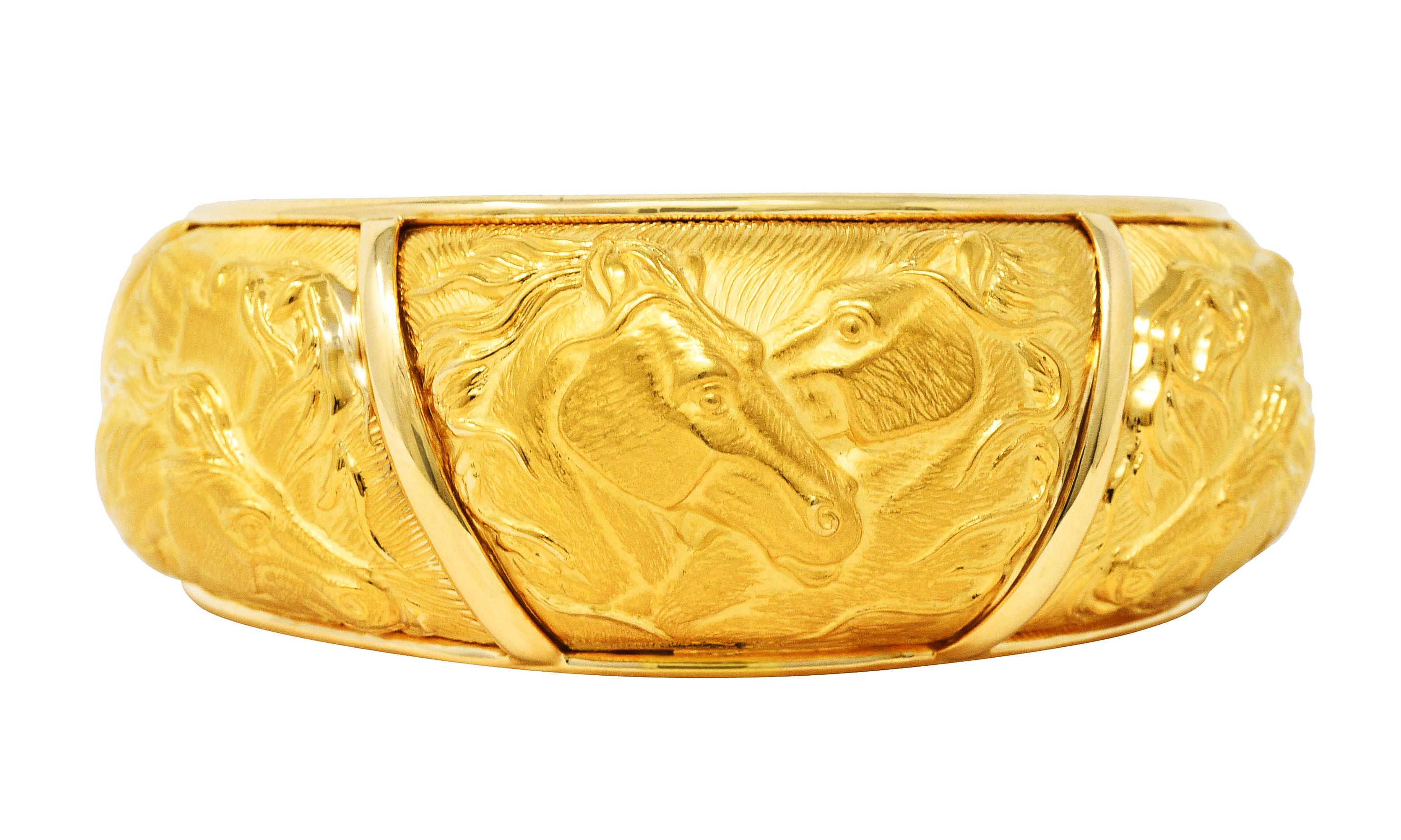 Cuff bracelet features five repoussè style panels depicting highly rendered matte gold horses

Background is highly texturized while panels are separated by polished gold bands

Stamped 750 for 18 karat gold

With maker's mark and serial number for