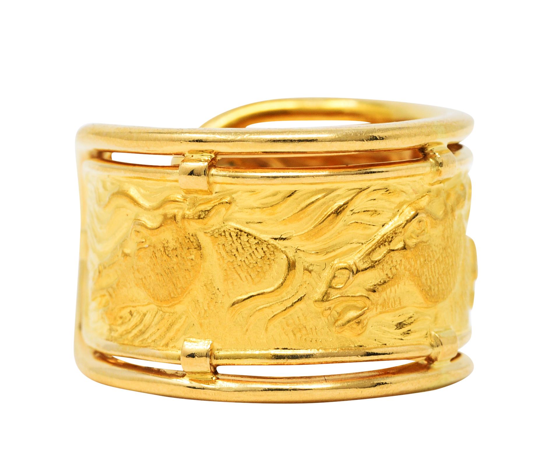 Cuff style repousse ring depicting horse heads with flowing manes

Featuring brushed gold texture

With high polished gold wire frame

Stamped 750 for 18 karat gold

With maker's mark for Carrera y Carrera

Ring Size: 6 1/2 and not sizable

Measure