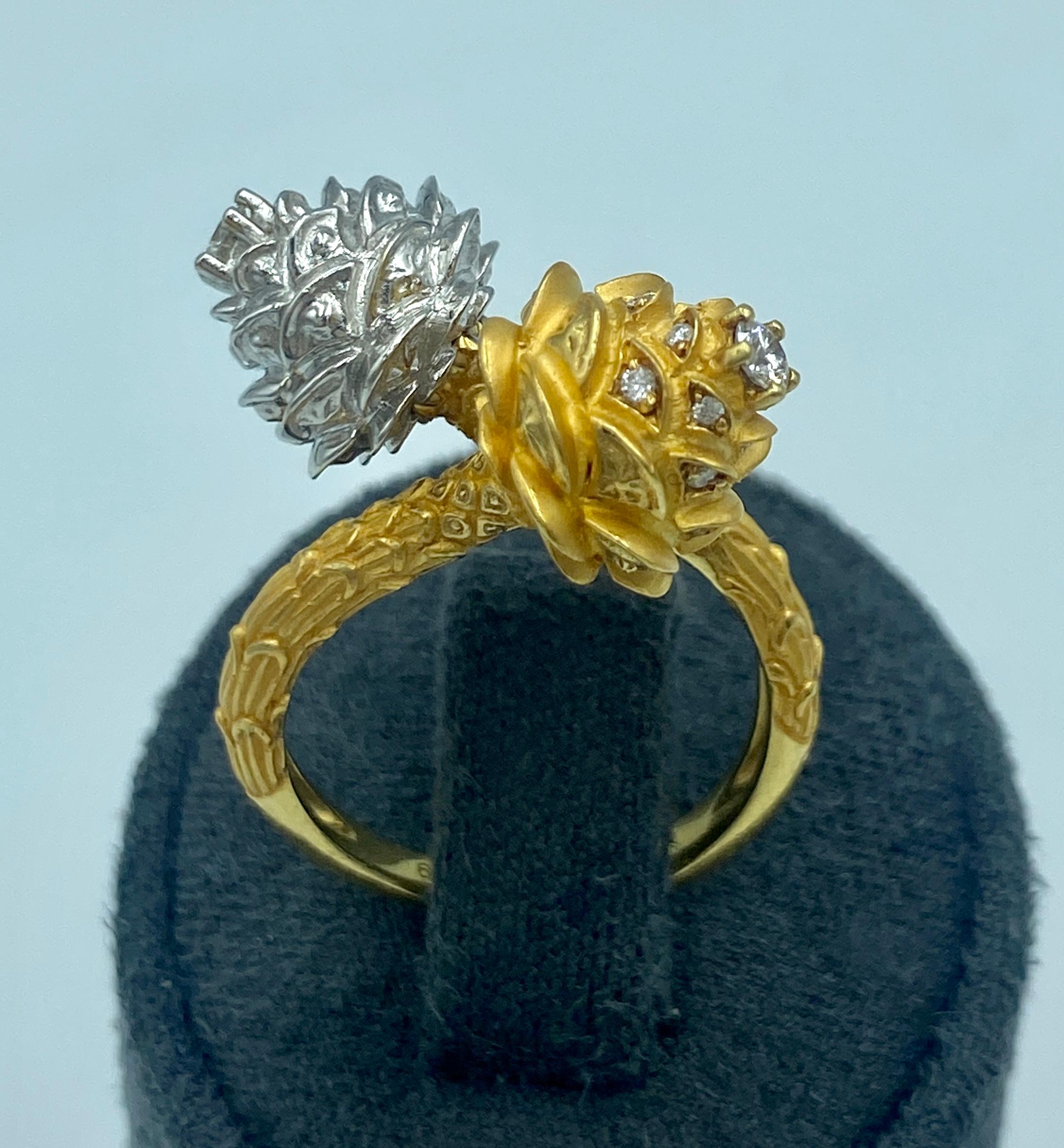 Dieser skurrile Ring mit zwei Tannenzapfen besteht aus 2 Eicheln, eine aus Weißgold, die andere aus Gelbgold. Beide Eicheln sind mit kleinen Diamanten im Rundschliff verziert.