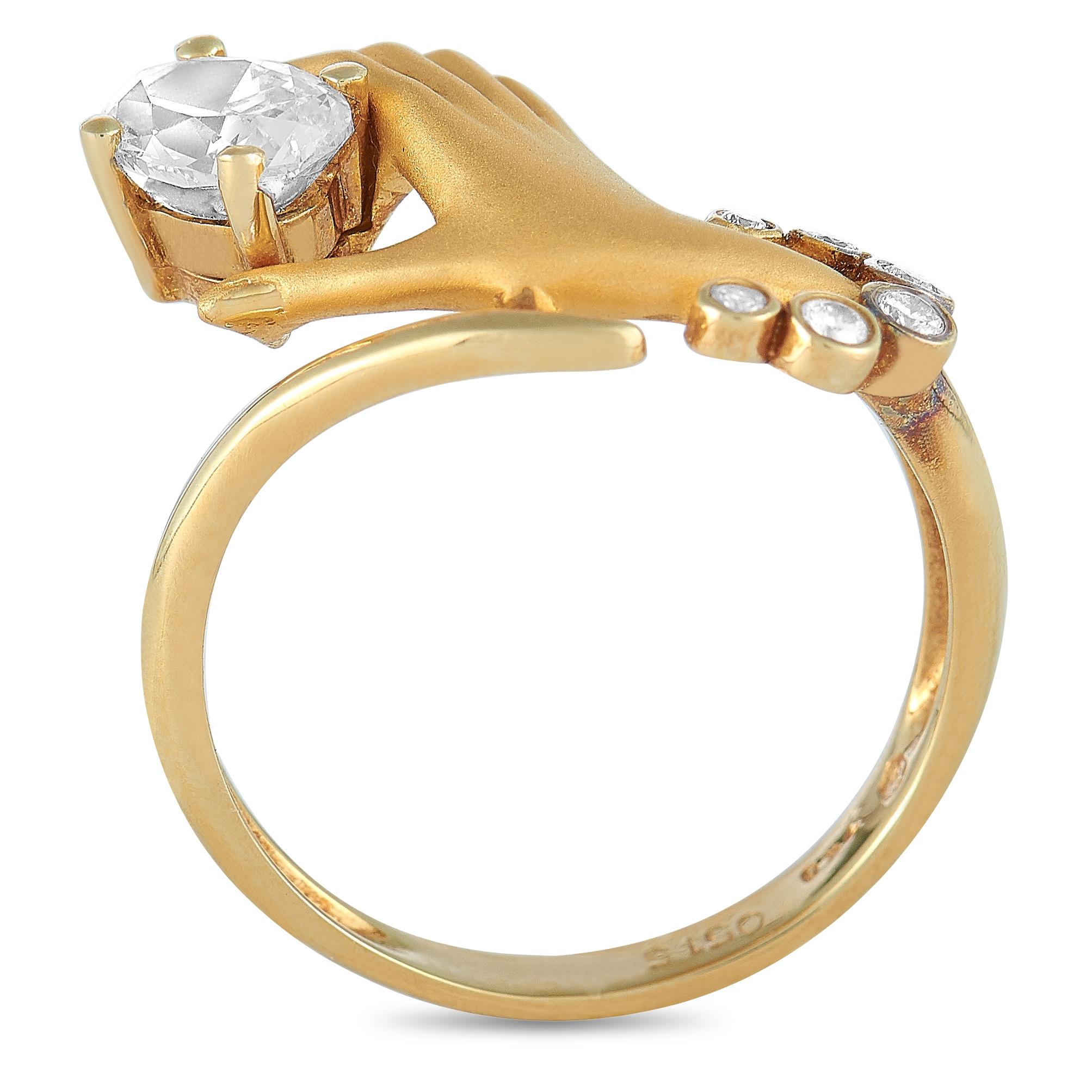 This Carrera y Carrera hand ring is crafted from 18K yellow gold and weighs 4.5 grams. It boasts band thickness of 2 mm and top height of 5 mm, while top dimensions measure 18 by 12 mm. The ring is set with a total of 0.60 carats of diamonds – the