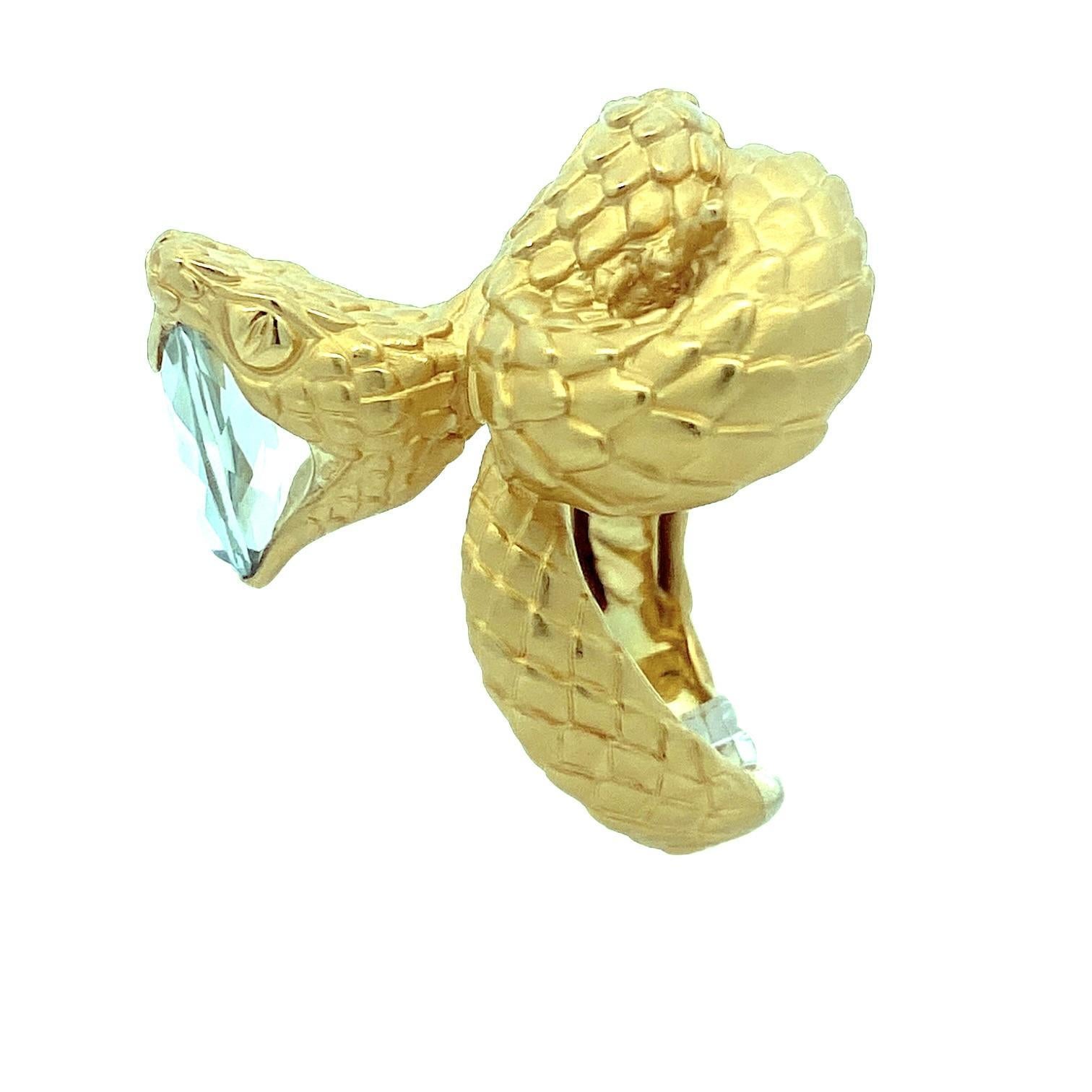 Carrera y Carrera 18K yellow gold statement ring. The design features a serpent motif intricately coiled around an oval-cut green quartz, weighing 2.0 carats. The serpent's scales are meticulously detailed, enhancing the ring's bold presence. The