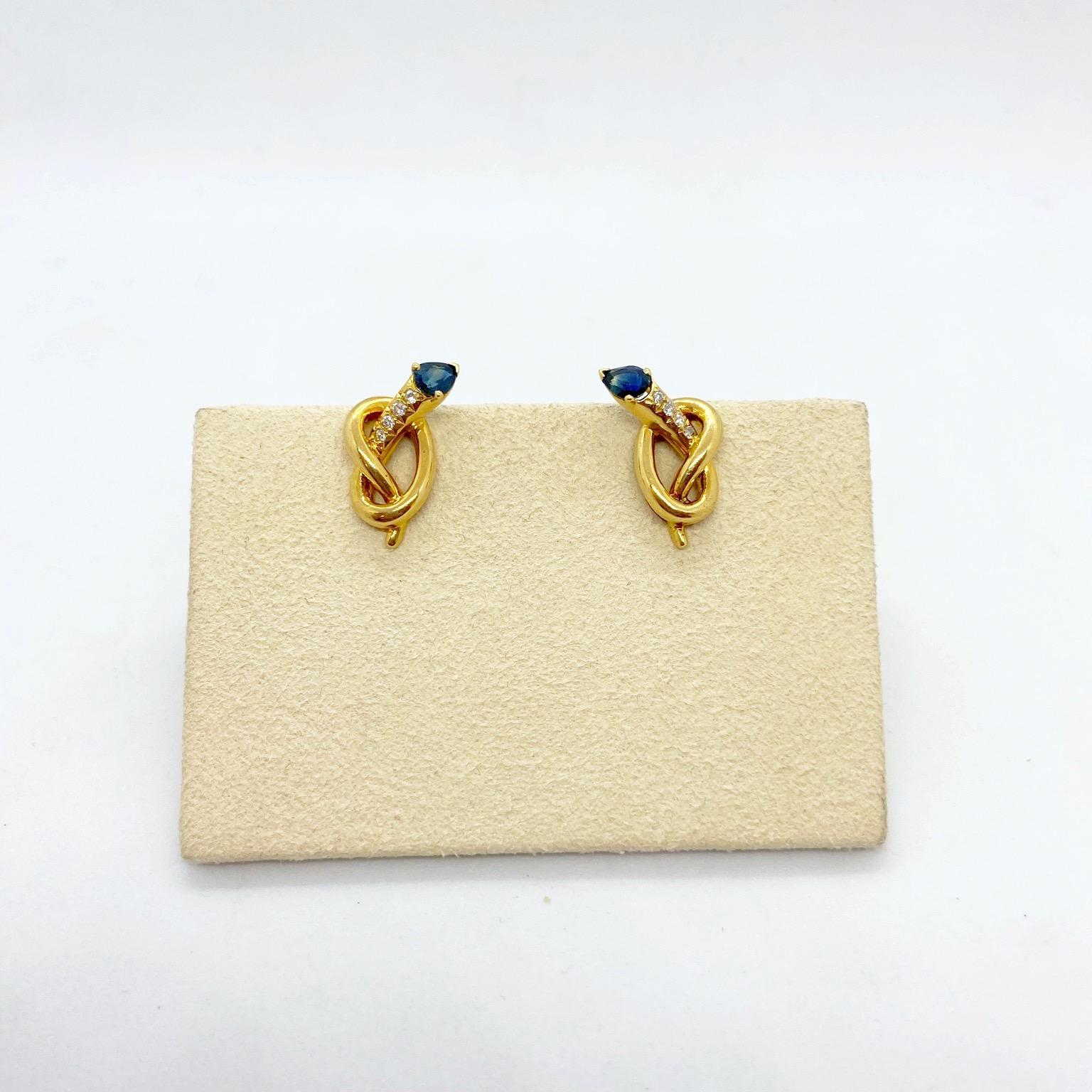 Designed by Carrera Y Carrera for Cellini NYC.
These 18 karat yellow gold knot earrings are set with .08 carats diamonds. Each tip is set with a pear shaped blue sapphire 0.90 carats. The earrings are clip on, posts can be added. They measure
