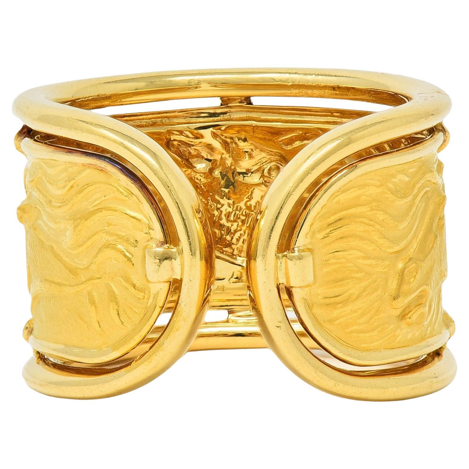 Centering a matte gold repoussé panel depicting wild horses
With high polish features and flowing manes
Set with high polish wire frame surround
With open rounded terminals
Stamped 18 karat gold
Numbered with maker's mark for Carrera y