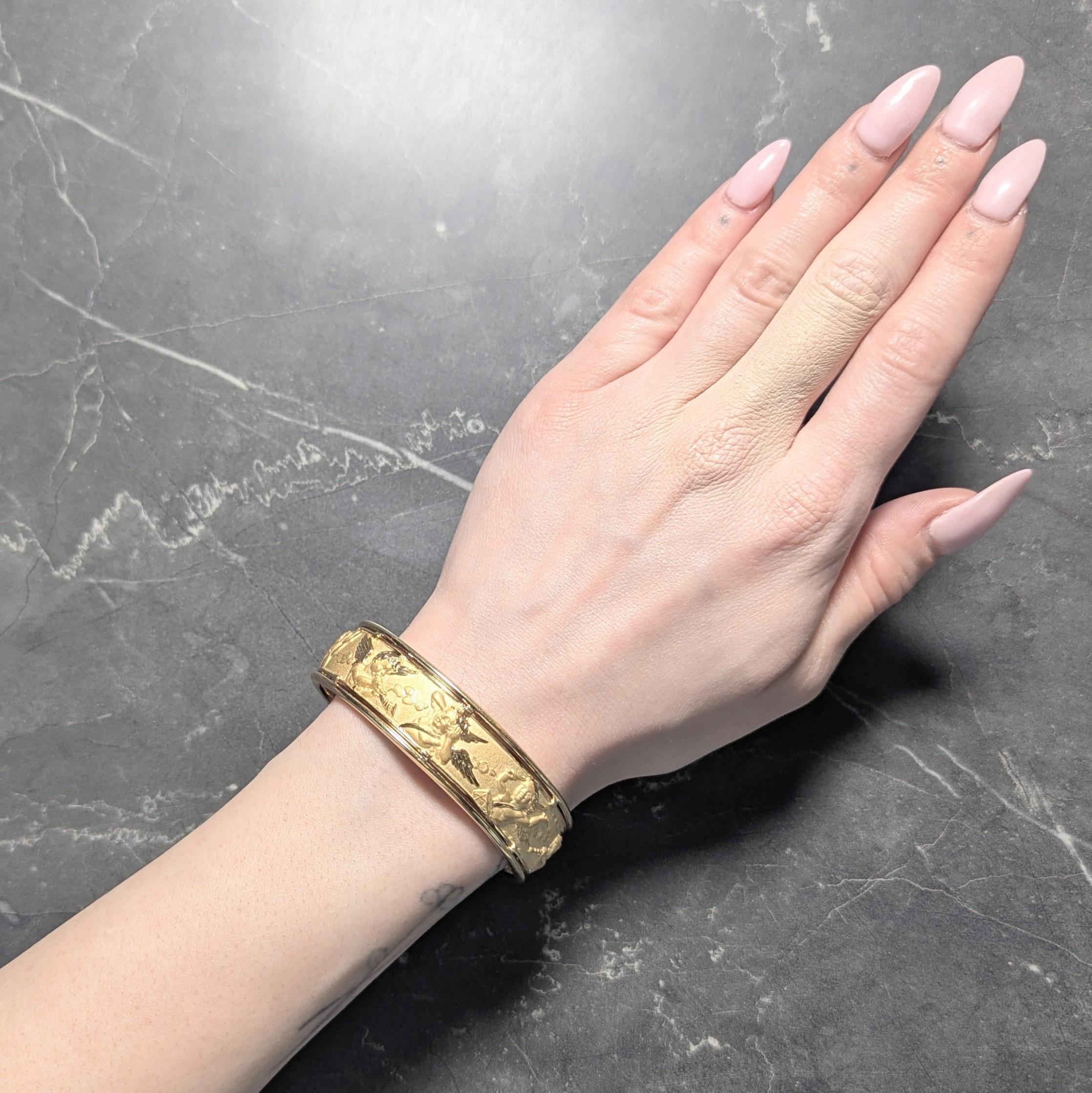 Al centro un pannello repoussé in oro opaco raffigurante cherubini che suonano vari strumenti
Accentuati da ali e capelli lucidati a specchio
Con cornice in filo d'oro lucidato a specchio
Con terminali aperti arrotondati
Timbrato per l'oro a 18