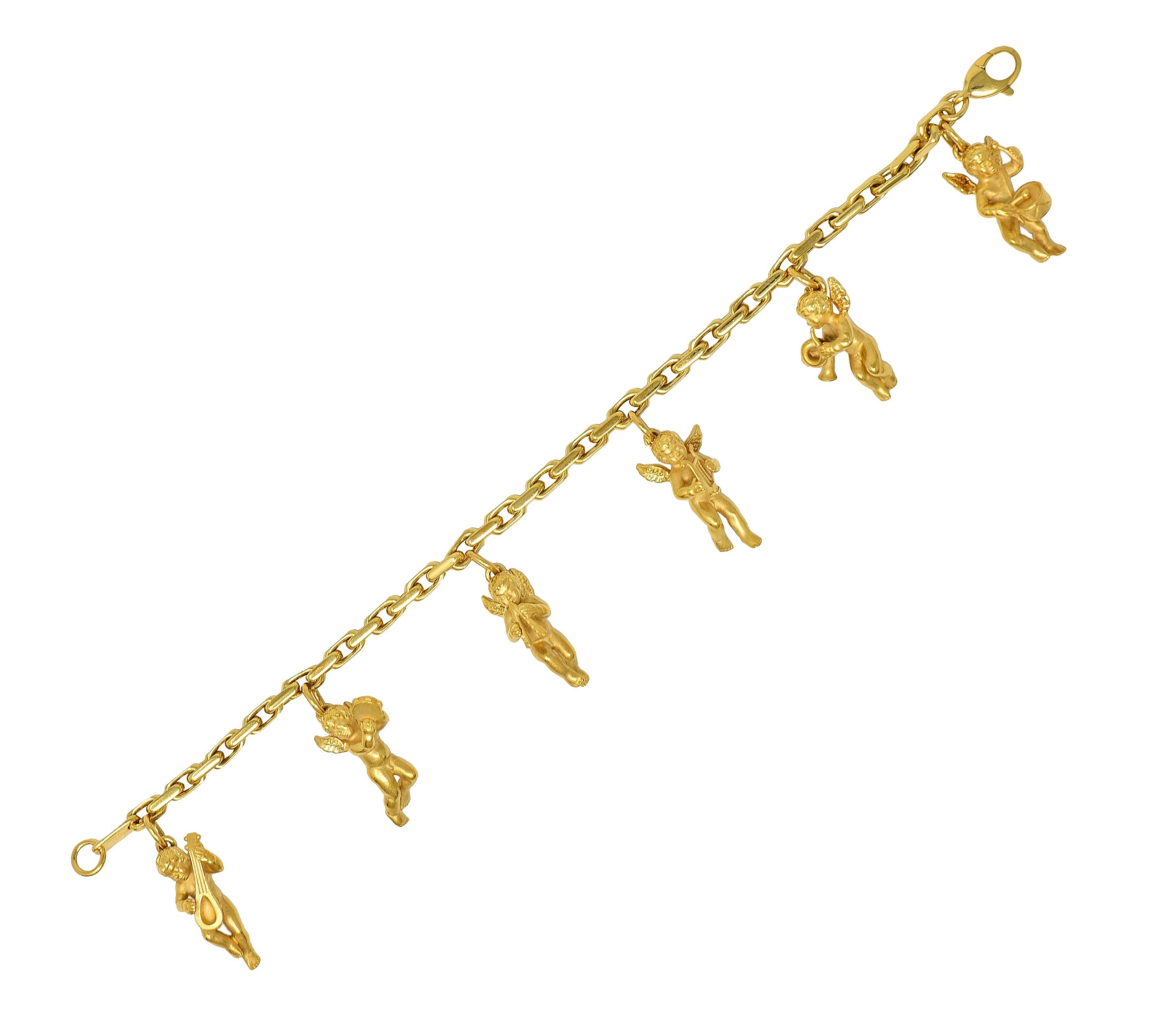 Designed as an elongated box link chain suspending six cherub charms
Highly rendered with textured hair and wings - each with an instrument
Including drums, horn, lyre, double flute, tambourine, and a lute 
Matte with high polished features
Each