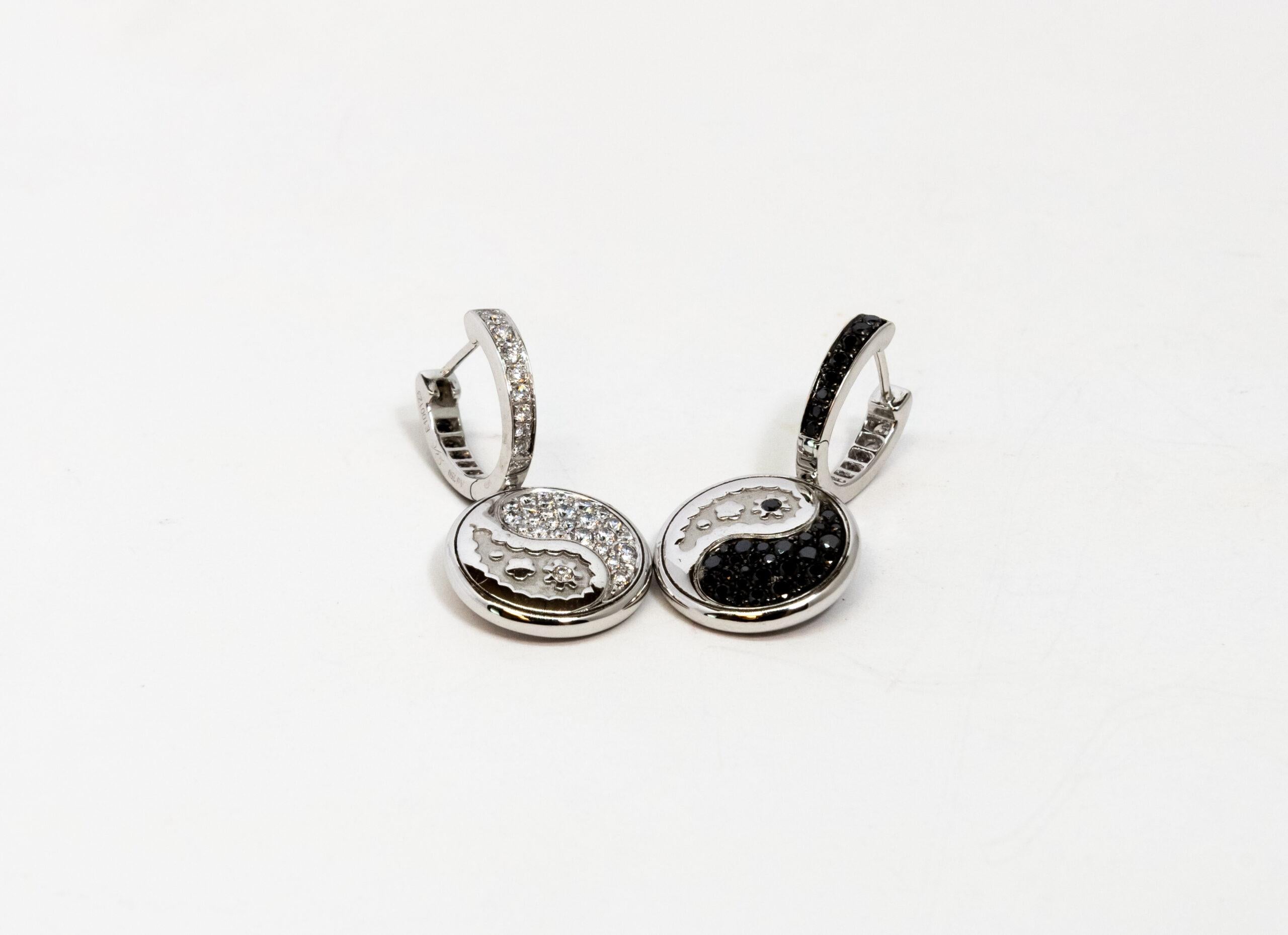 This 18K White Gold English lock earring. Decorated as Yin Yang symbols. Each piece is double sided. One side set with white diamonds and other side set with black diamonds. Diamonds totaling ~0.59ct. Latch back.

Dimensions: 1.1 cm x 3 cm
