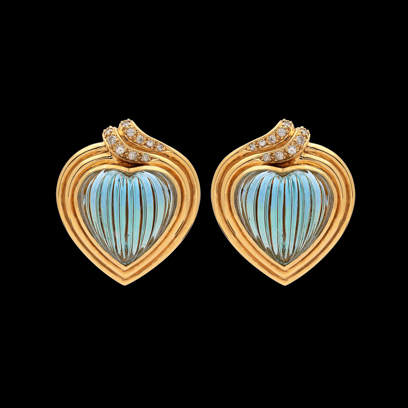 Beautifully made by Spanish brand Carrera y Carrera, these 18k yellow gold earrings feature two carved and fluted heart-shaped aquamarines, together weighing approximately 22-cts., with double rimmed gold frames and highlighted by 24 round