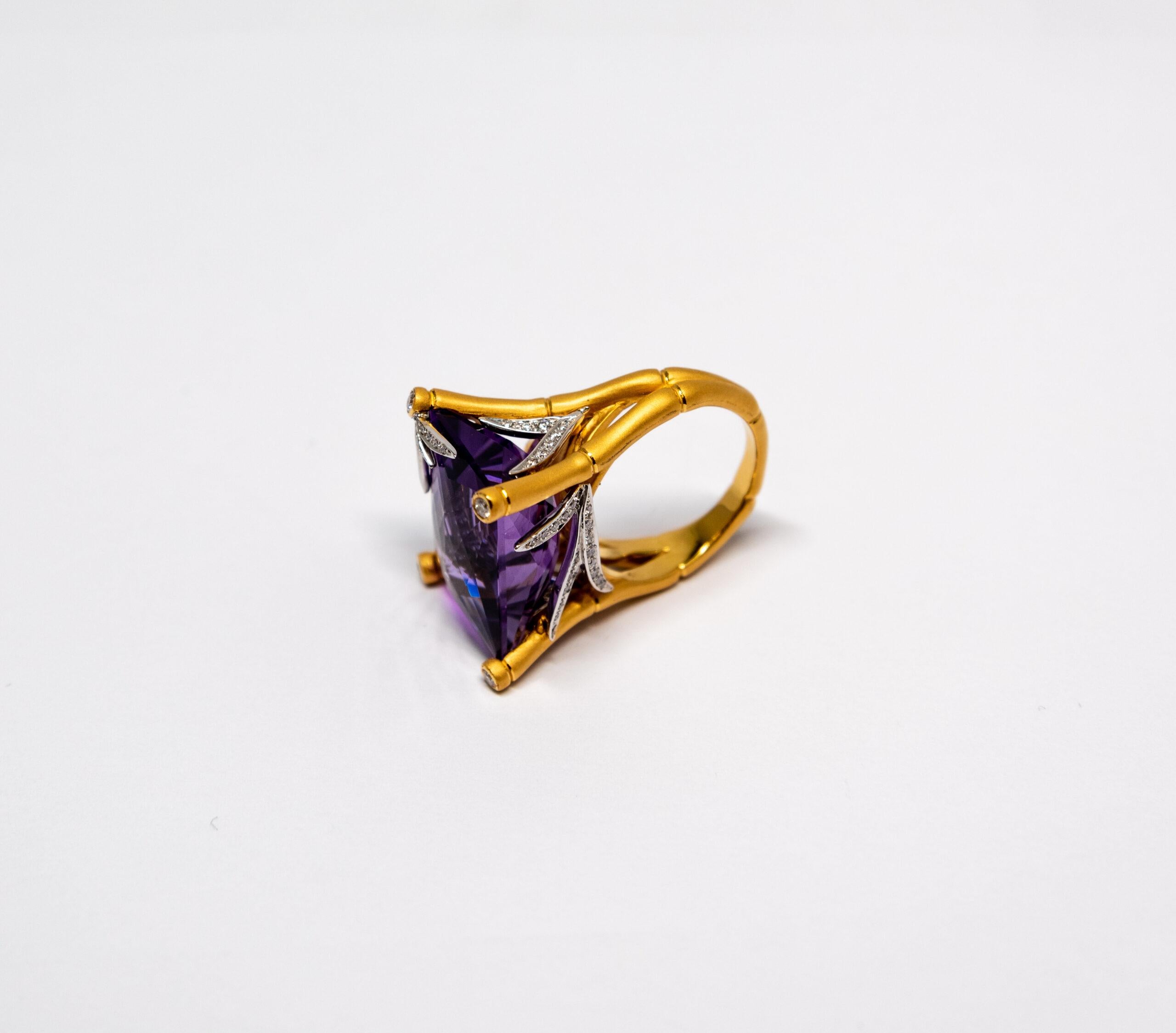 This ring is made of 18K Yellow Gold. The top of the ring is decorated with large Amethyst (~21.55ct). The Amethyst stone is fixed by 4 bamboo-shaped branches with white gold and diamonds “leaves”. Diamonds are totaling ~0.42ct.

Size – 56 (7.5 US)