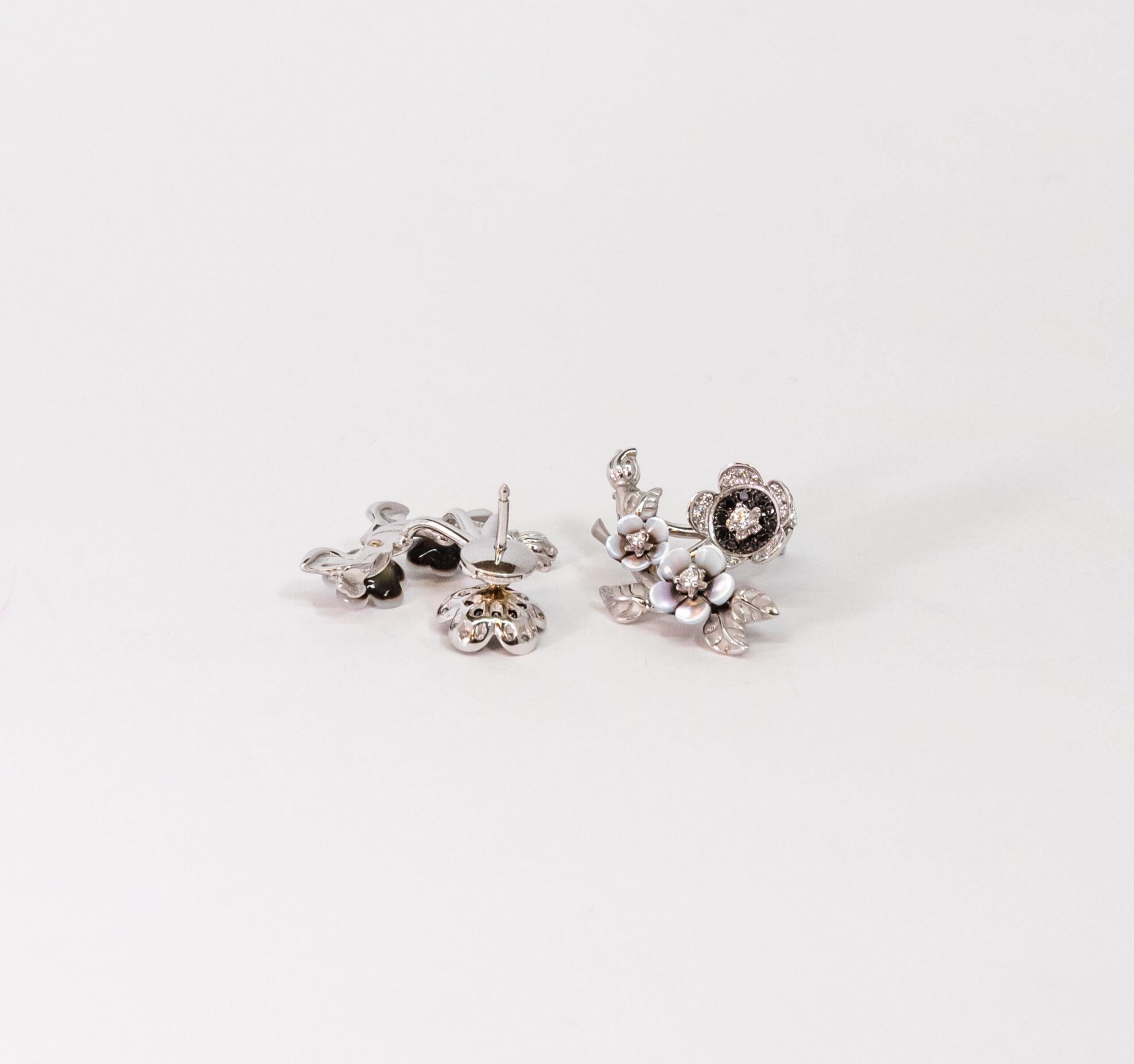 10070437 Carrera y Carrera
This 18K White Gold stud earring is made as spring of flowers. Two Mother of Pearl flowers set with 2 diamonds. Third flower figure set with 16 White diamonds and 10 Black Diamonds. All Diamonds are totaling ~0.56ct. Push