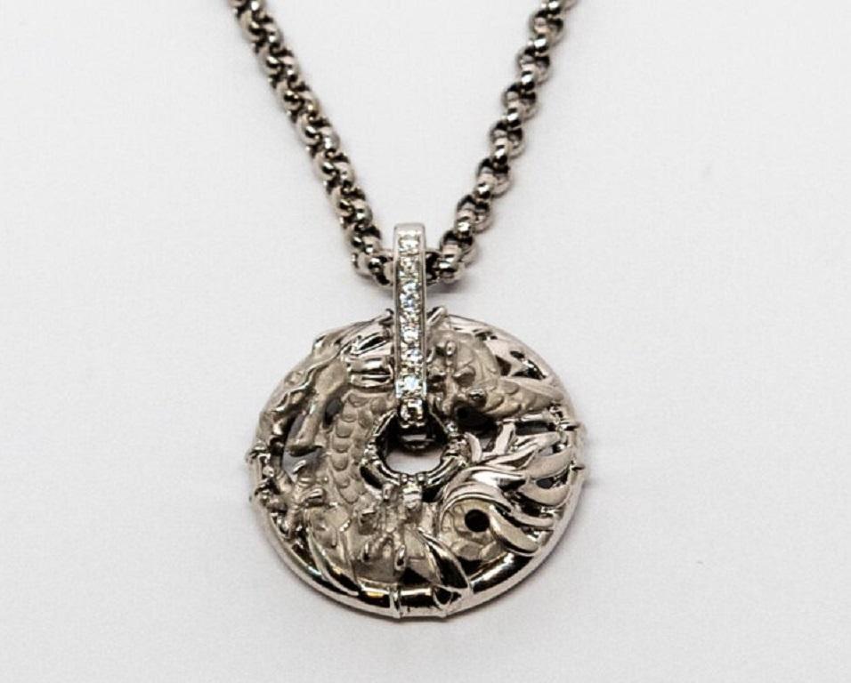 18K White Gold pendant. It is decorated with an 18K Yellow Gold dragon figure and 8 diamonds (~0.10ct).

Chain Length: 22 cm

Pendant dimensions: 2.4 x 2.4 cm