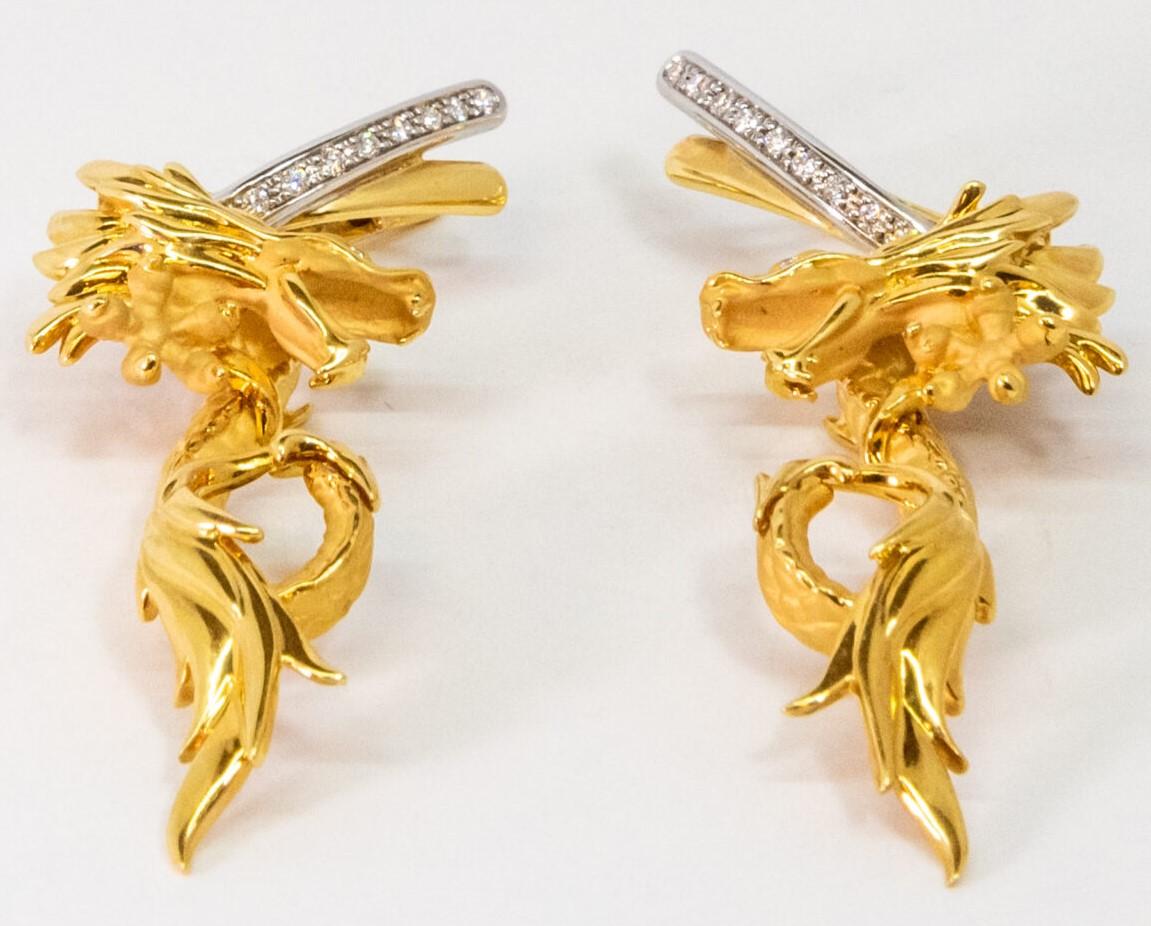10076359 Carrera y Carrera
This 18K Yellow Gold dangler earring. Dragon-shaped 18K Yellow gold figures with “diamond eyes” and 18K White Gold lock part set with 9 Diamonds ( totaling ~0.18ct). Latch back.

Dimensions: 6.3 cm x 2 cm