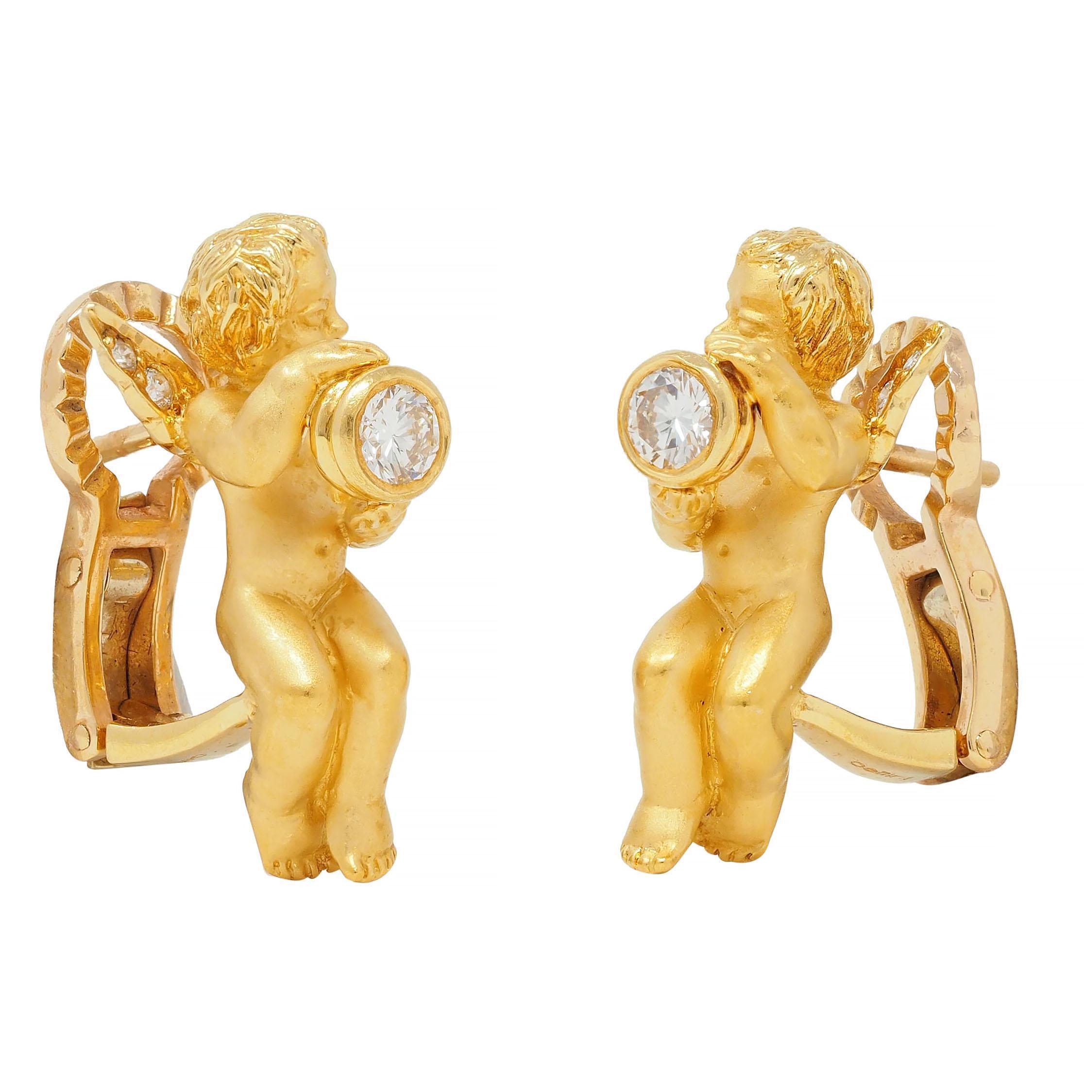 Designed as highly rendered winged cherubs with matte bodies and high polished textured hair
Depicted holding bezel set round brilliant cut diamonds 
With additional diamonds bead set in wings
Weighing approximately 0.38 carat total - G color with