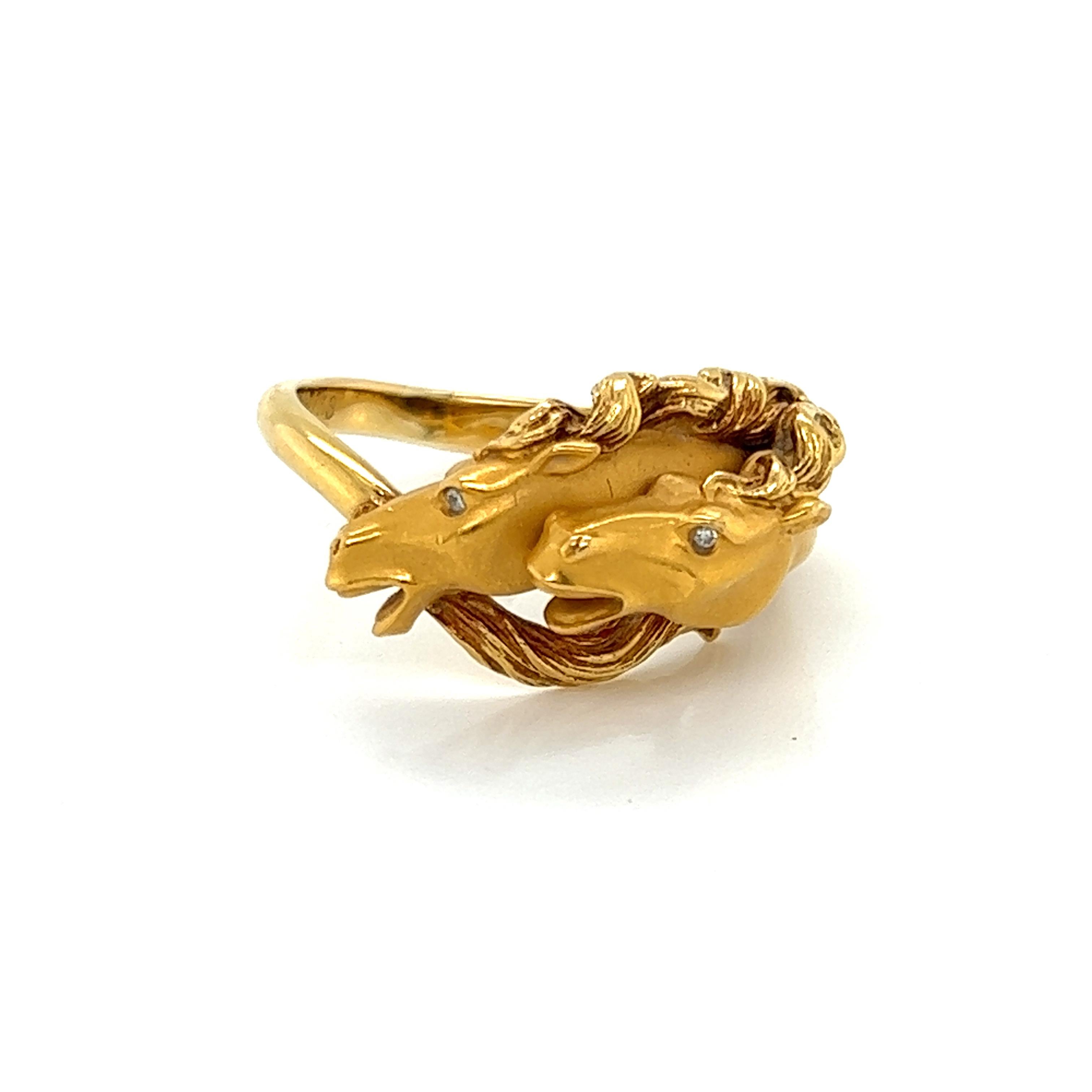 This authentic band ring is by Carrera y Carrera from the Horse Collection. It is crafted from 18k yellow gold with a smooth satin finish, it features 2 horses head in a playful pose, they have small round diamond as eyes and flowing mane. The neck