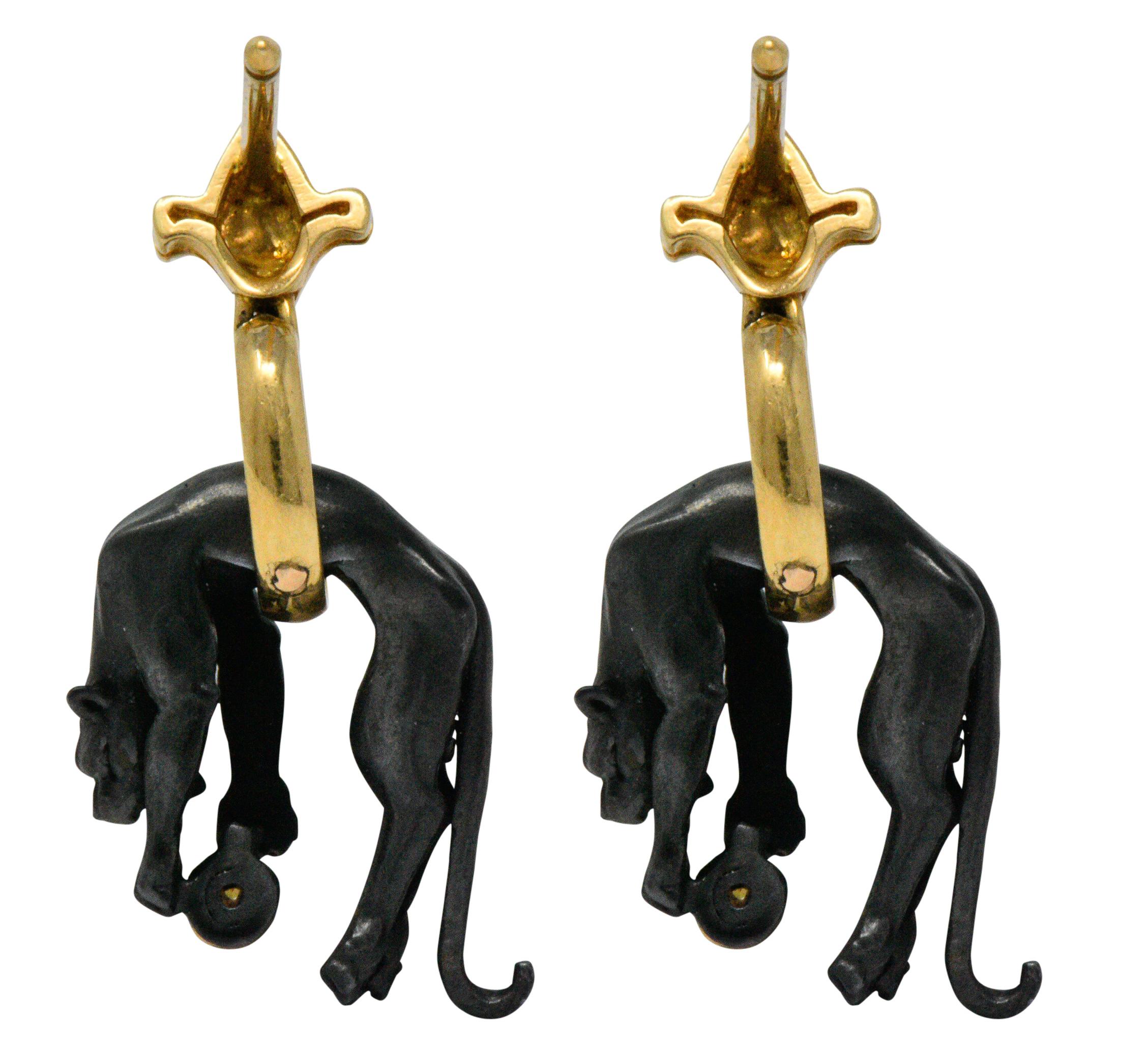 Designed as articulated black anodized gold panthers toying with a diamond ball  

Each accented with a round brilliant cut diamond, weighing approximately 0.06 carat total, eye-clean and white

With polished gold surmounts

Post and locking earring