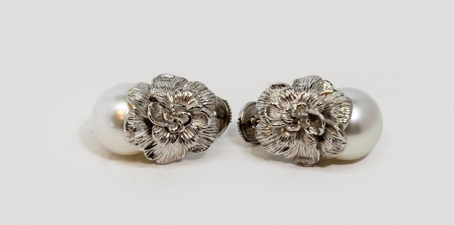 18K White Gold stud earring. It is decorated with flower and pearl (~2.00un).  Push back.

Dimensions: 1.7 cm x 2.2 cm