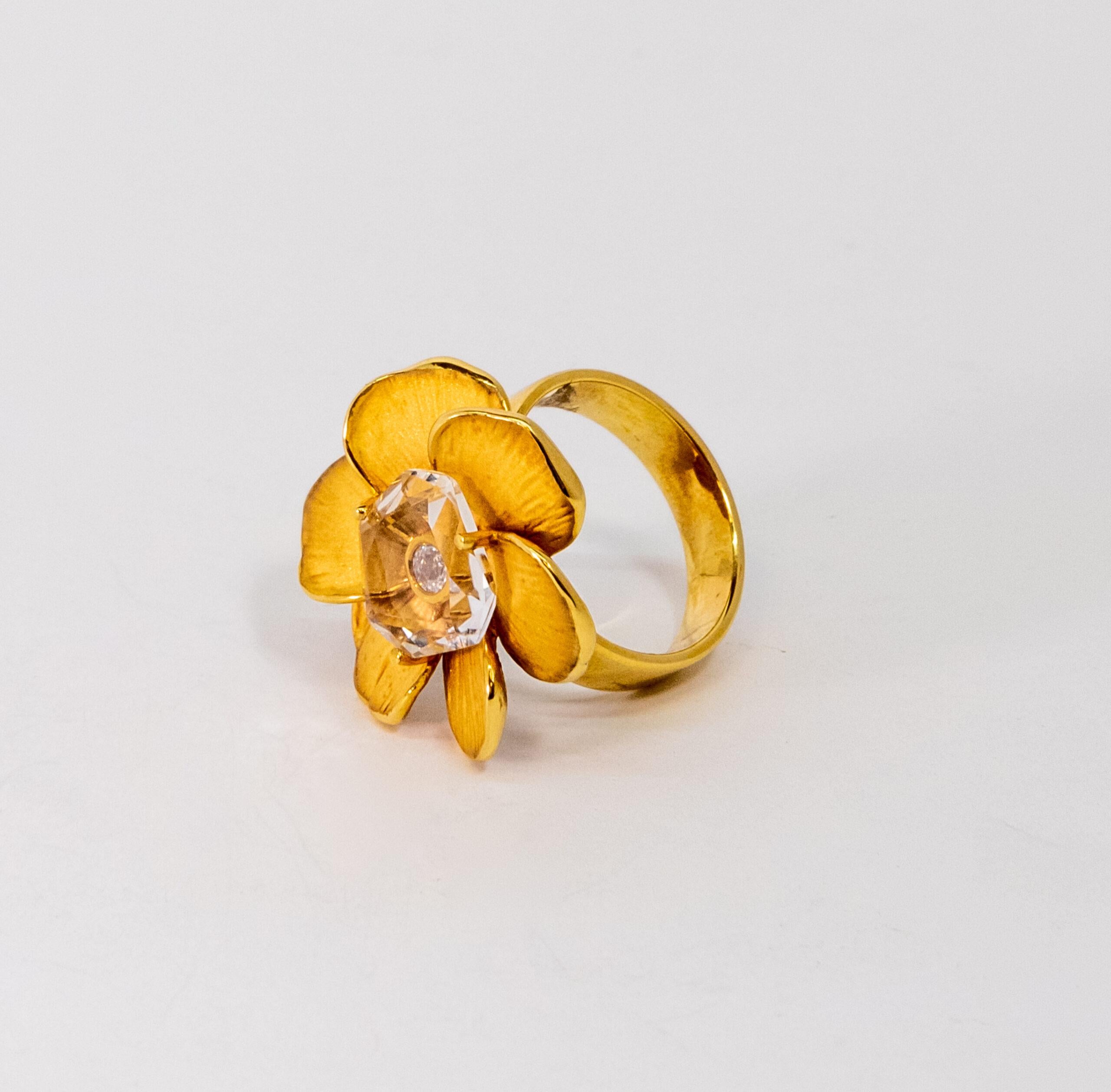 This ring is made of 18K Yellow Gold. It is designed as a flower with a diamond (~0.09ct) covered by crystal (1.00 un).

Size – 55 (7 US)