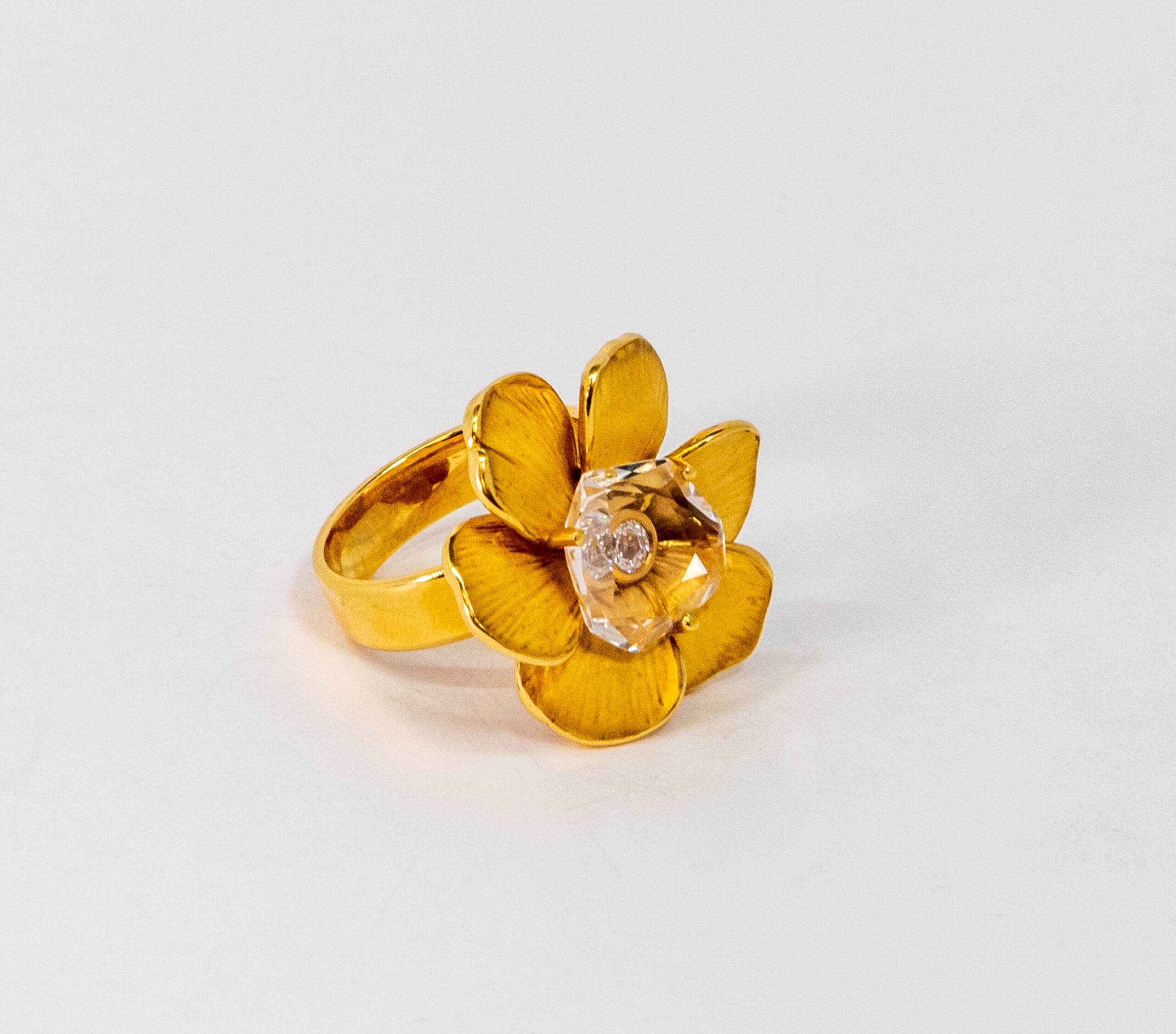 This ring is made of 18K Yellow Gold. It is designed as a flower with a diamond (~0.09ct) covered by crystal (1.00 un).

Size – 55 (7 US)