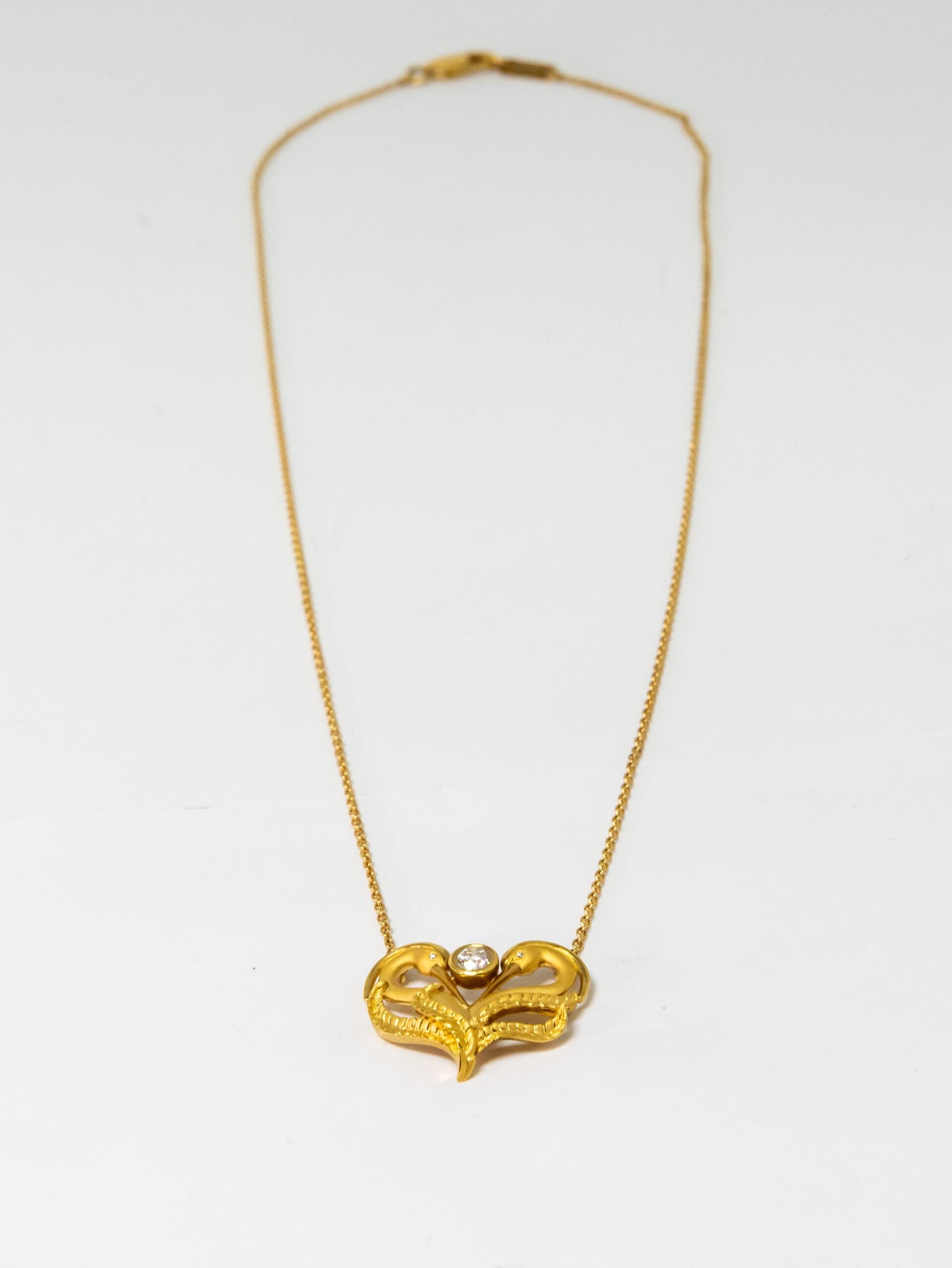 18K Yellow Gold pendant. 18K Yellow Gold Rolo chain with lobster claw lock. Two figures of 18K Yellow Gold cranes placed in the heart shape. The main Diamond (~0.20ct) in the middle. The eyes of the cranes made with diamonds (~0.01ct)

Length: 23 cm