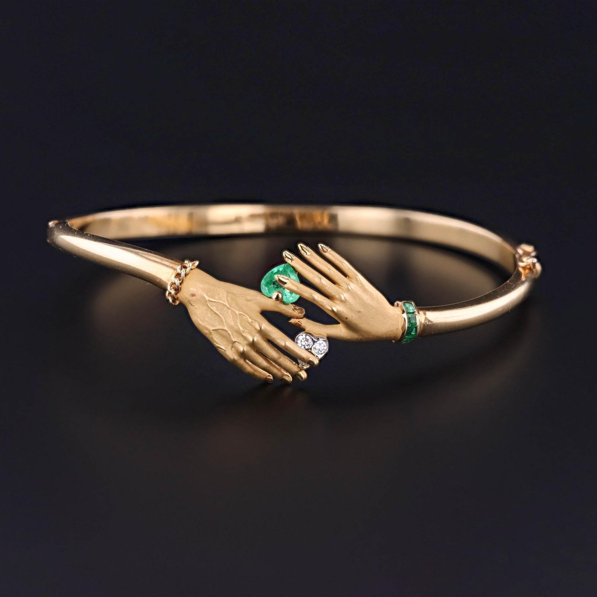 Bracciale Manos di Carrera y Carrera: Questo eccezionale braccialetto bangle di Carrera y Carrera mostra una mano maschile che tiene un cuore di diamante e una mano femminile che tiene un cuore di smeraldo. Viene venduto con l'astuccio e la scatola