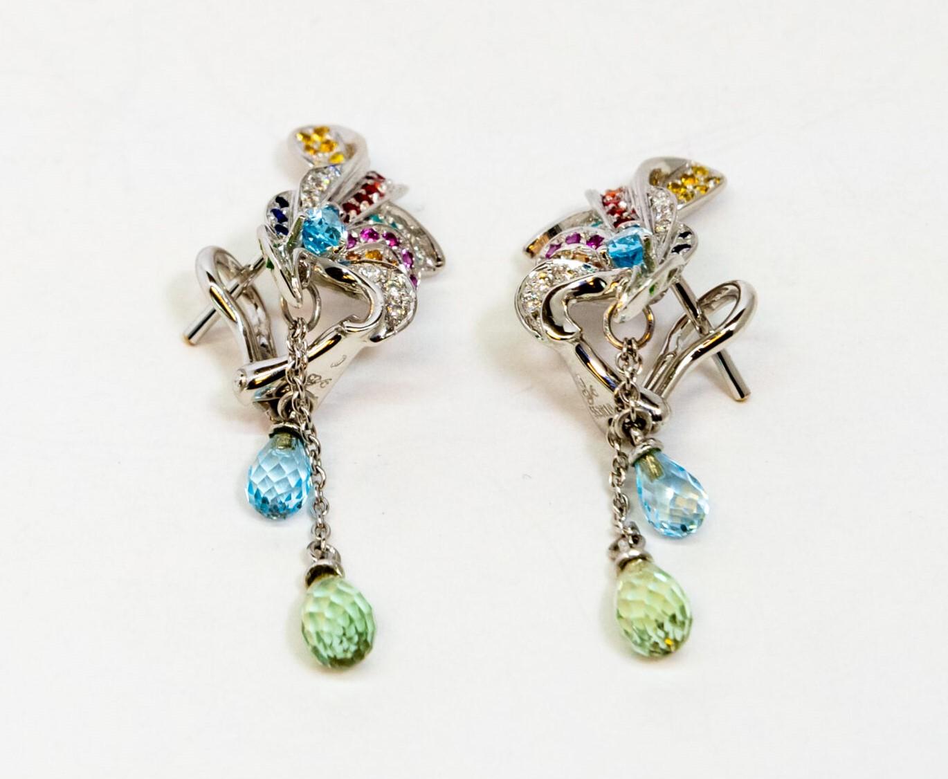 This 18K White Gold plug earring. Unique-shaped 18K White gold figures set with blue, pink, orange, red, white, green and yellow Sapphires and 2 teardrop Sapphires (green and blue). French back.

Dimensions: 5 cm x 1.2 cm