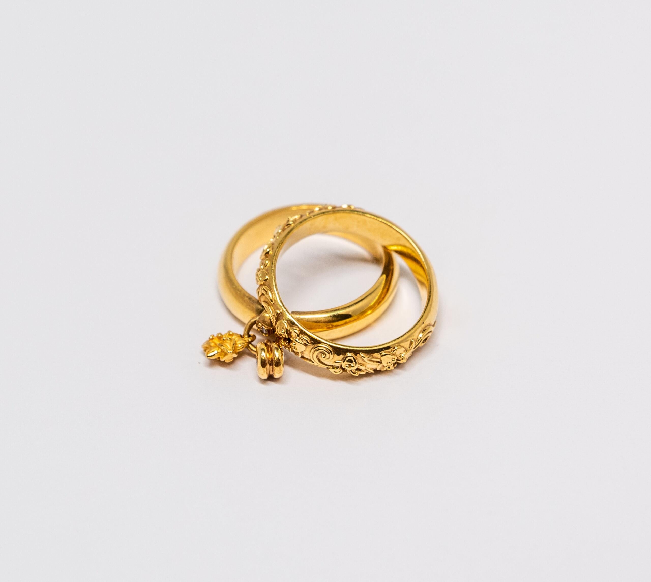 This ring is made of 18K Yellow Gold. Two rings are connected by link. One ring is smooth and the second ring is decorated with a floral pattern and Diamonds.

Size – 54 (7 US)