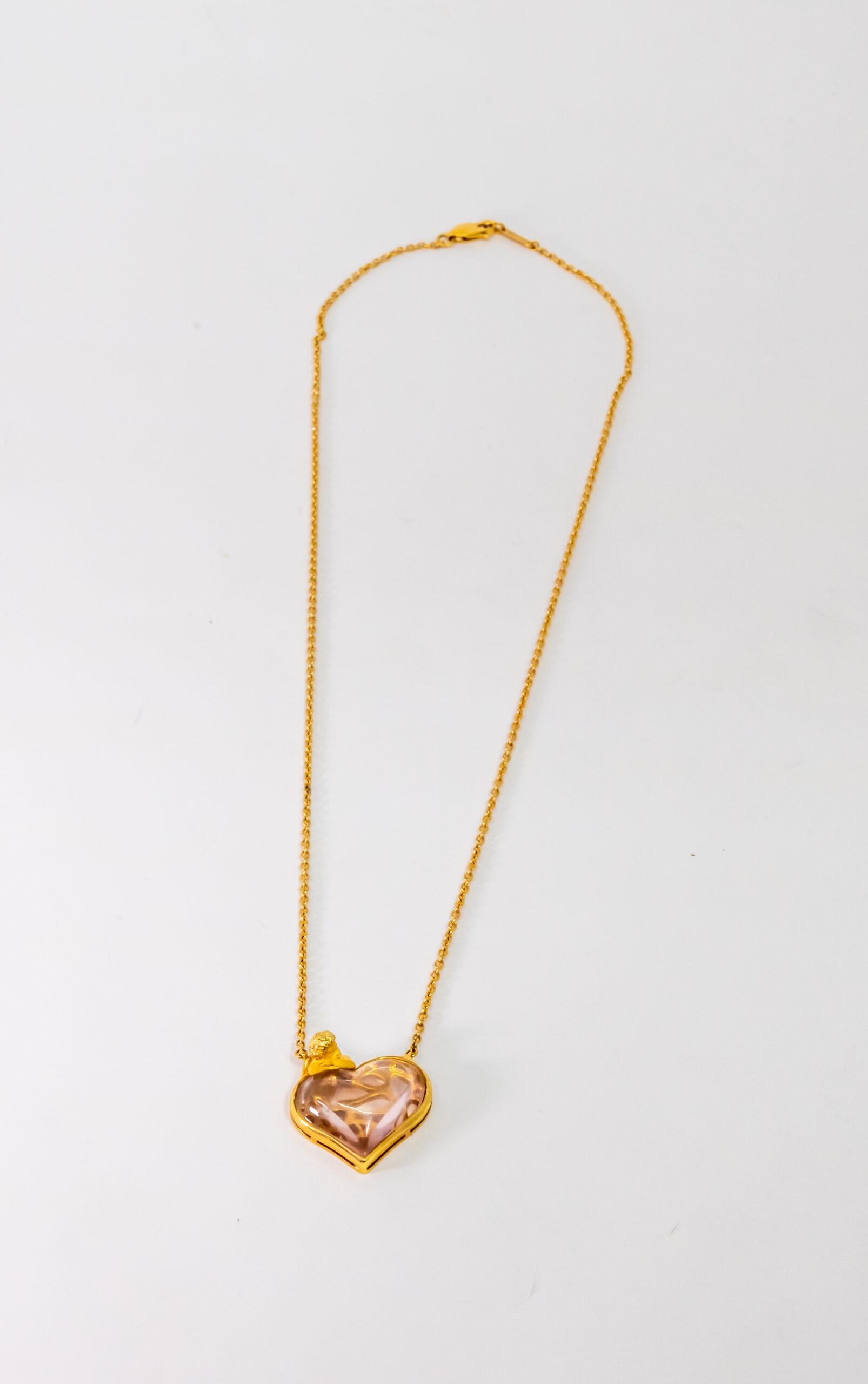 Pendentif en or jaune 18 carats. Chaîne Rolo en or jaune 18K avec fermoir à pinces de homard. Cette pièce est ornée d'une figure d'ange en or jaune et d'un pendentif en cristal de roche en forme de cœur.

Longueur : 23 cm