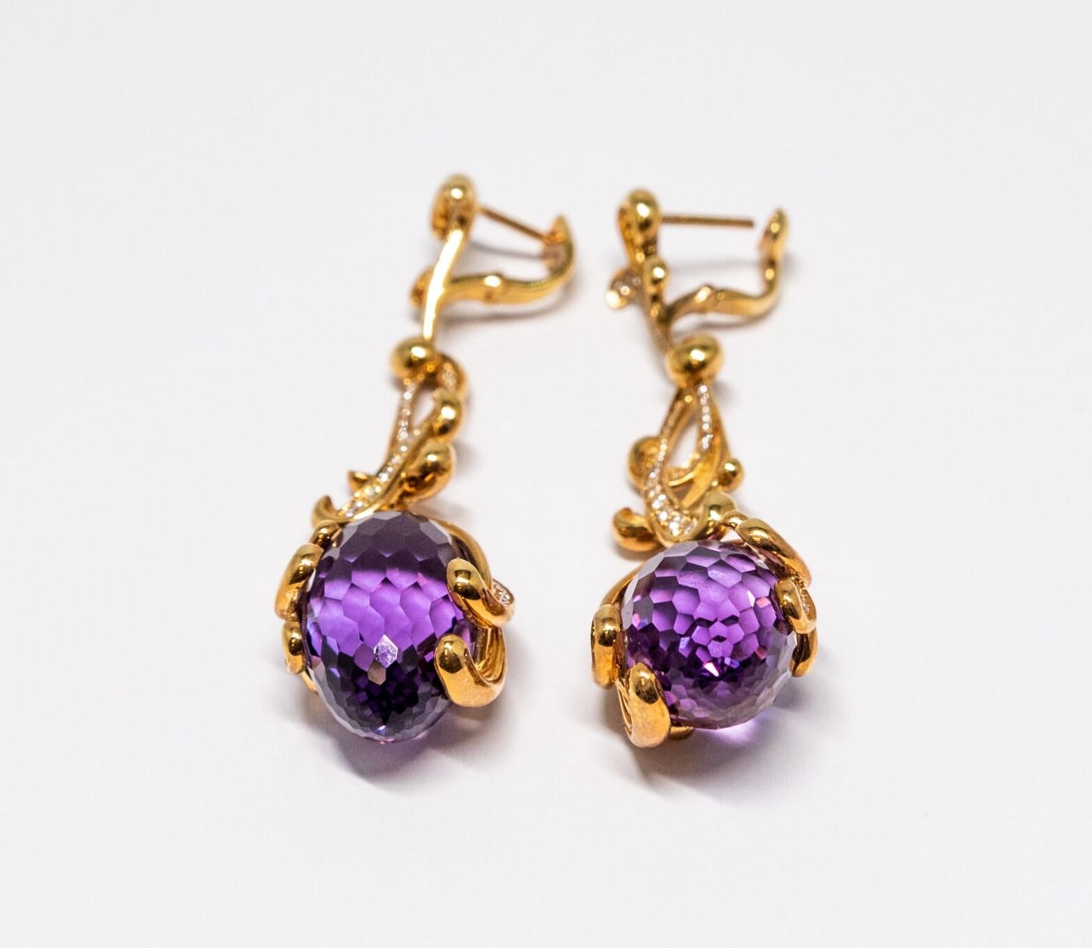 This 18K Yellow Gold English lock earring. Earrings set with 55 Diamonds (~0.62ct) and a large Amethyst stone 9 (40.42ct).  Latch back.

Dimensions: 6 cm x 2 cm