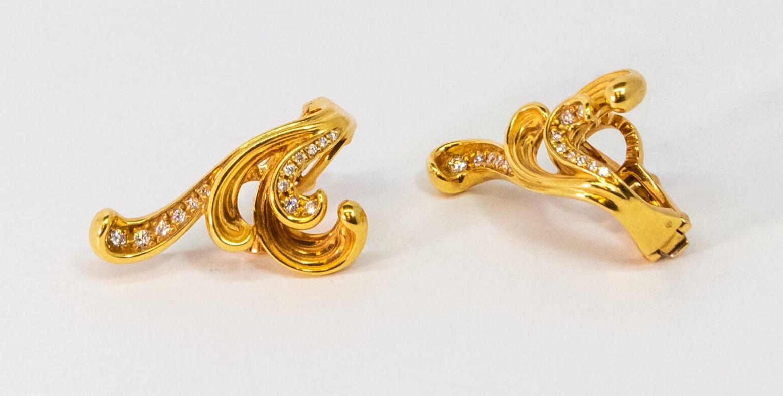 This 18K Yellow Gold English lock earring. Wavy patterns set with 14 Diamonds (~0.18ct). Latch back.

Dimensions: 2 cm x 2 cm