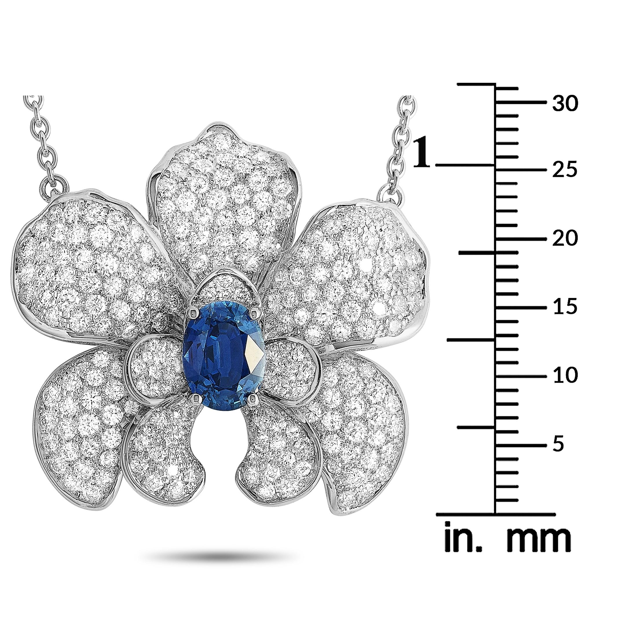 The Carrera y Carrera “Orquídeas” necklace is made of 18K white gold and embellished with a 1.56 ct sapphire and a total of 2.93 carats of diamonds. The necklace weighs 11.98 grams and is presented with a 16” chain and a pendant that measures 1.12”