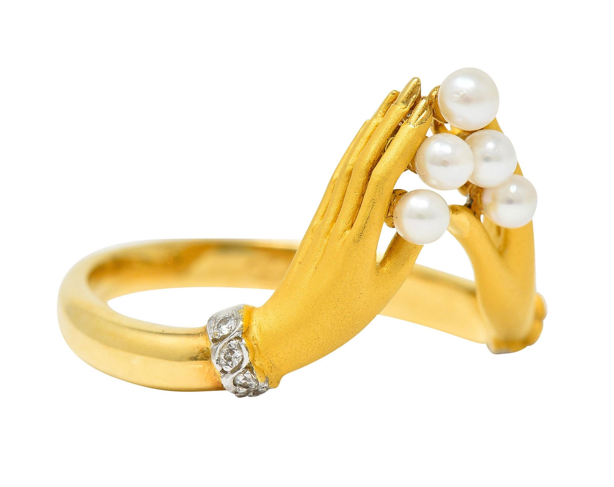 Chevron style ring is comprised of two highly rendered and matte gold hands

Holding 2.5 mm round pearls - very well matched in white body color and very good in luster

White gold cuffs are accented by round brilliant cut diamonds weighing in total