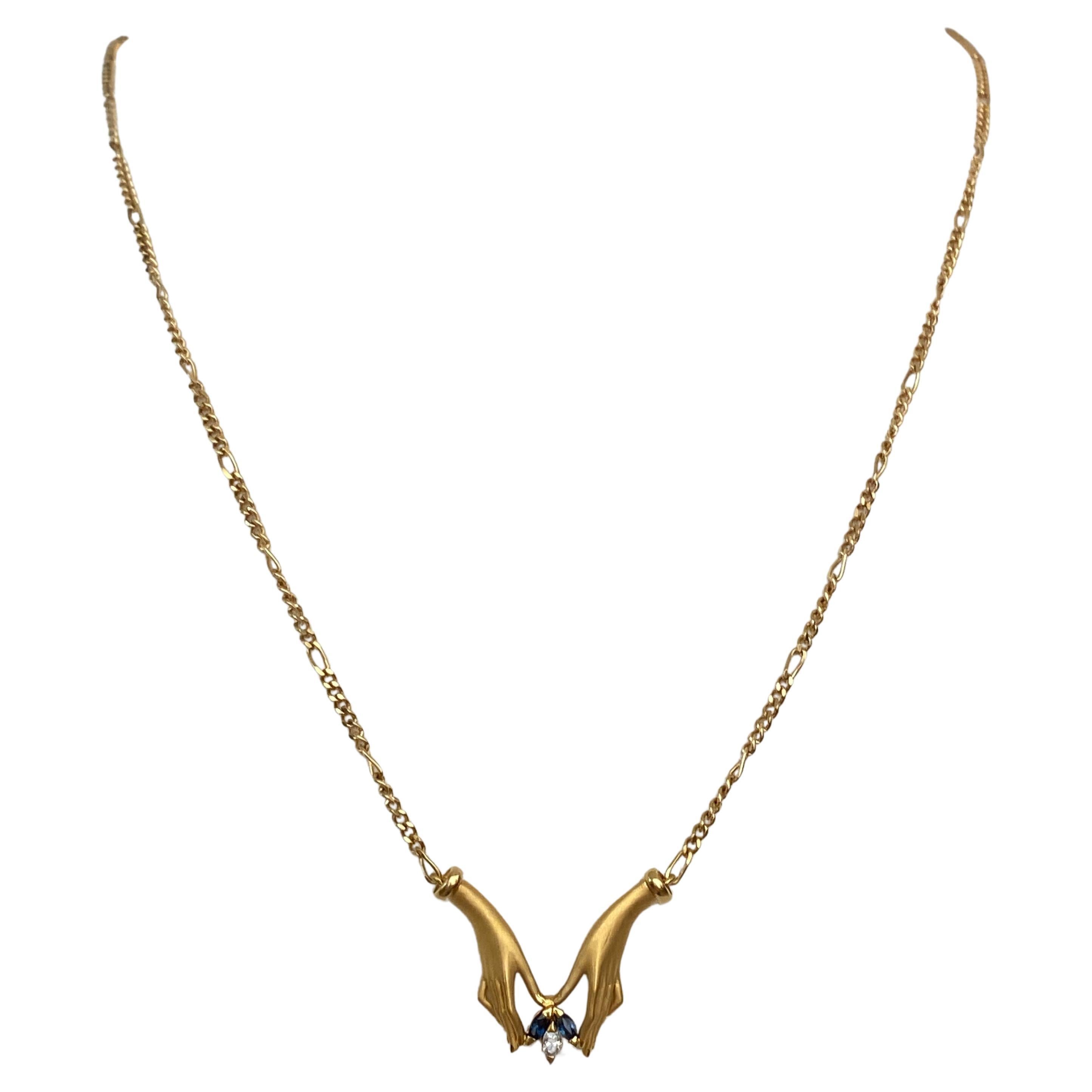 Angeboten von  18 kt Gelbgold Halskette der Marke Carrera y Carrera. Hand Motif Anhänger ist mit einem marquise geschliffenen Diamanten ca. 0,05 crt G/VS und zwei marquise geschliffenen Saphiren insgesamt 0,10 crt verziert. Die Halskette  ist