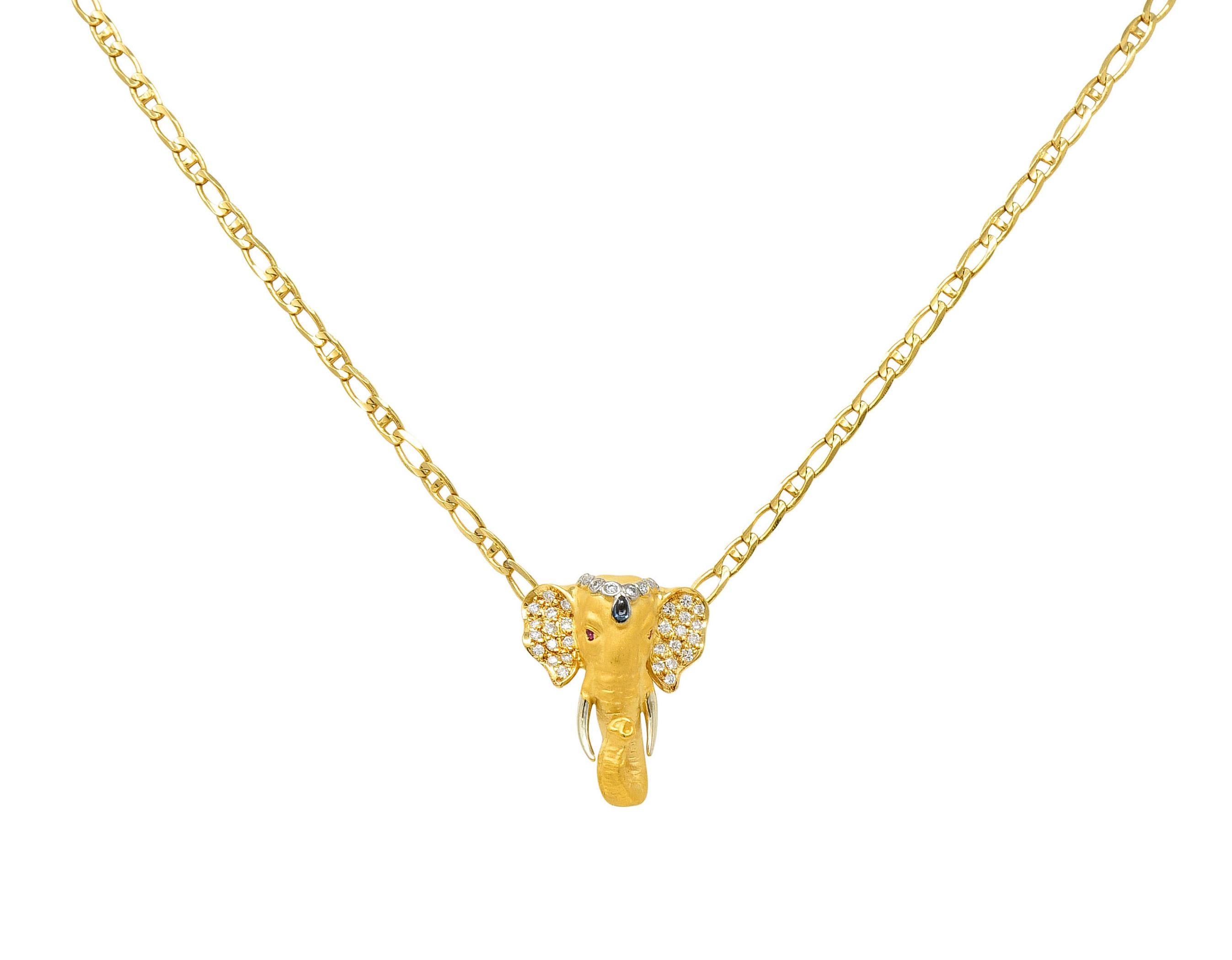 Cuban style chain features a highly rendered elephant bust at its center

Elephant is matte gold with an upturned trunk - symbolic of good luck

Accented by round brilliant cut diamonds, a pear cabochon sapphire, and round cut rubies

Weighing in