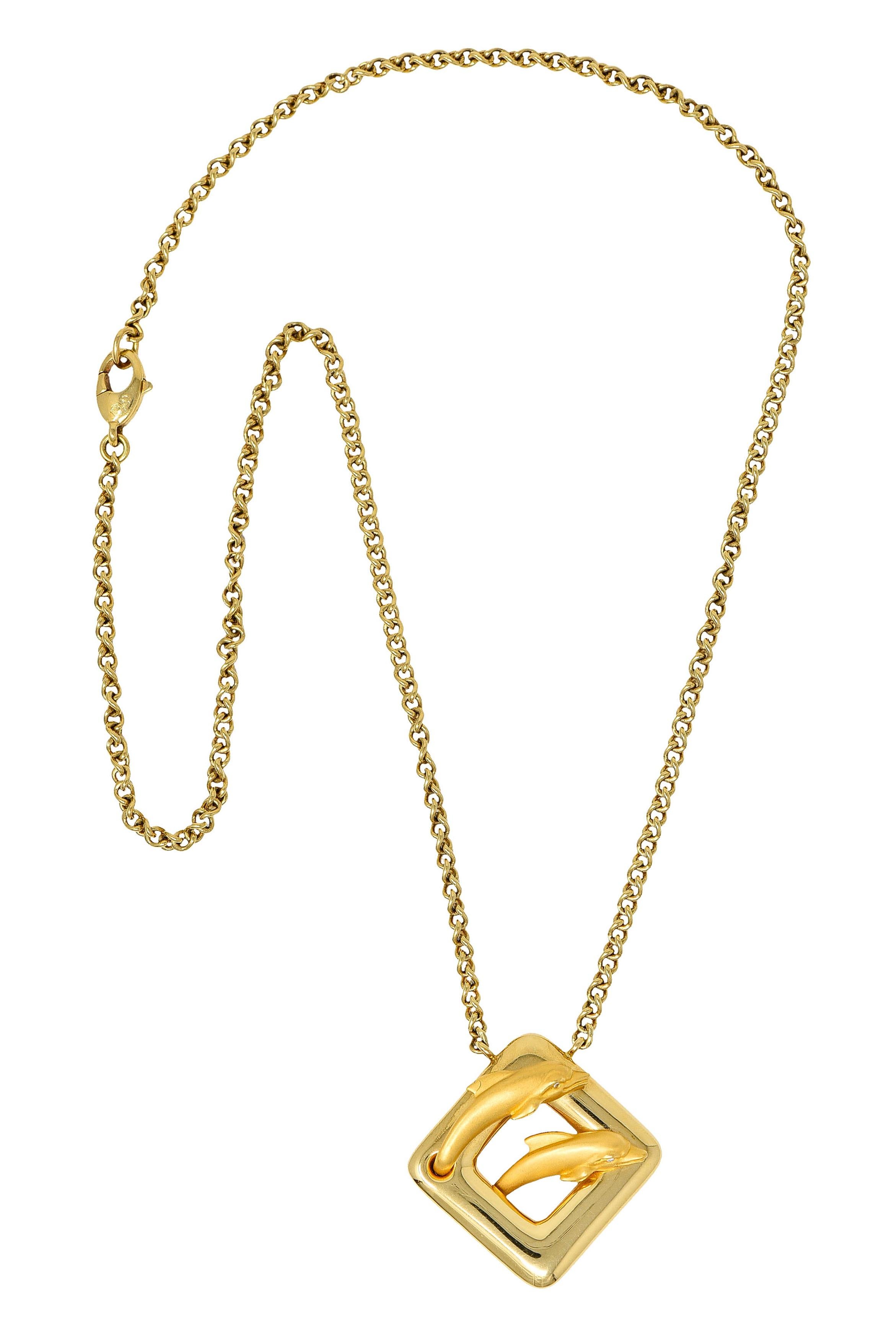 Curb chain necklace centers a brightly polished cushion shaped station

Featuring two matte finished and highly rendered dolphins with diamond accent eyes

Completed by a lobster clasp

Station and chain are stamped 750 for 18 karat gold

Both have