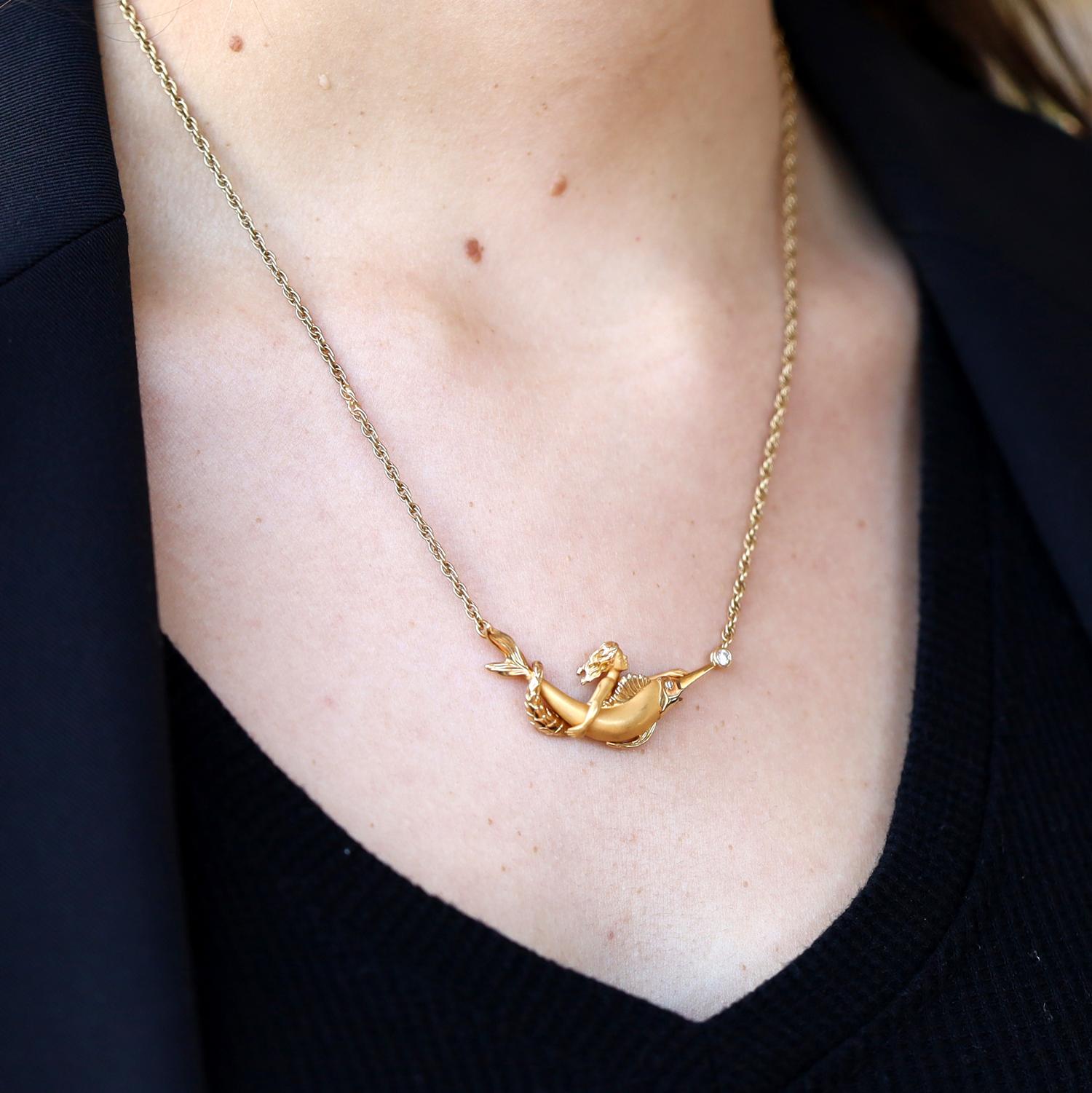 A fantastical flight of fancy by Carrera y Carrera, the necklace crafted of luminous 22 karat yellow gold, depicting a mermaid and swordfish splashing through the surf. Composed as a bar-style necklace of 18k gold with a pair of diamond accents,
