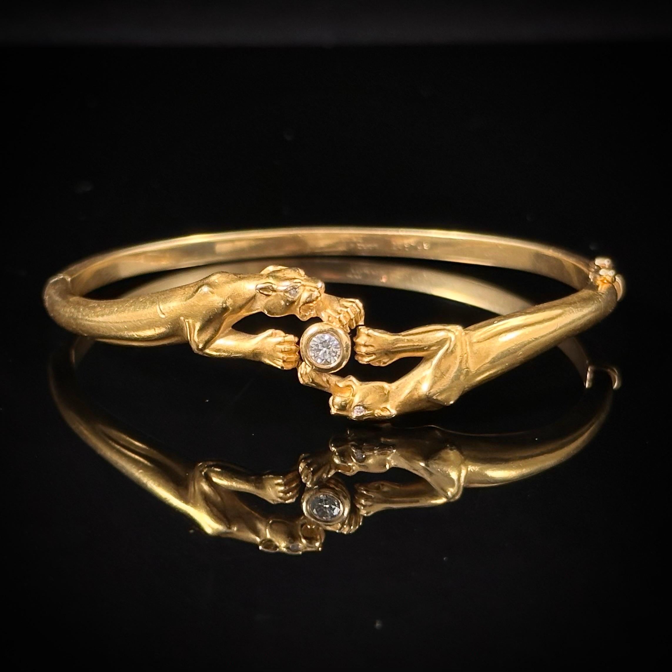 Carrera y Carrera vintage double panther diamond bangle bracelet in 18kt yellow gold, Spain, circa 1980s. This sleek and stylish bangle depicts two fierce panthers with sparkling diamond eyes fighting over a bezel-set round brilliant-cut diamond,