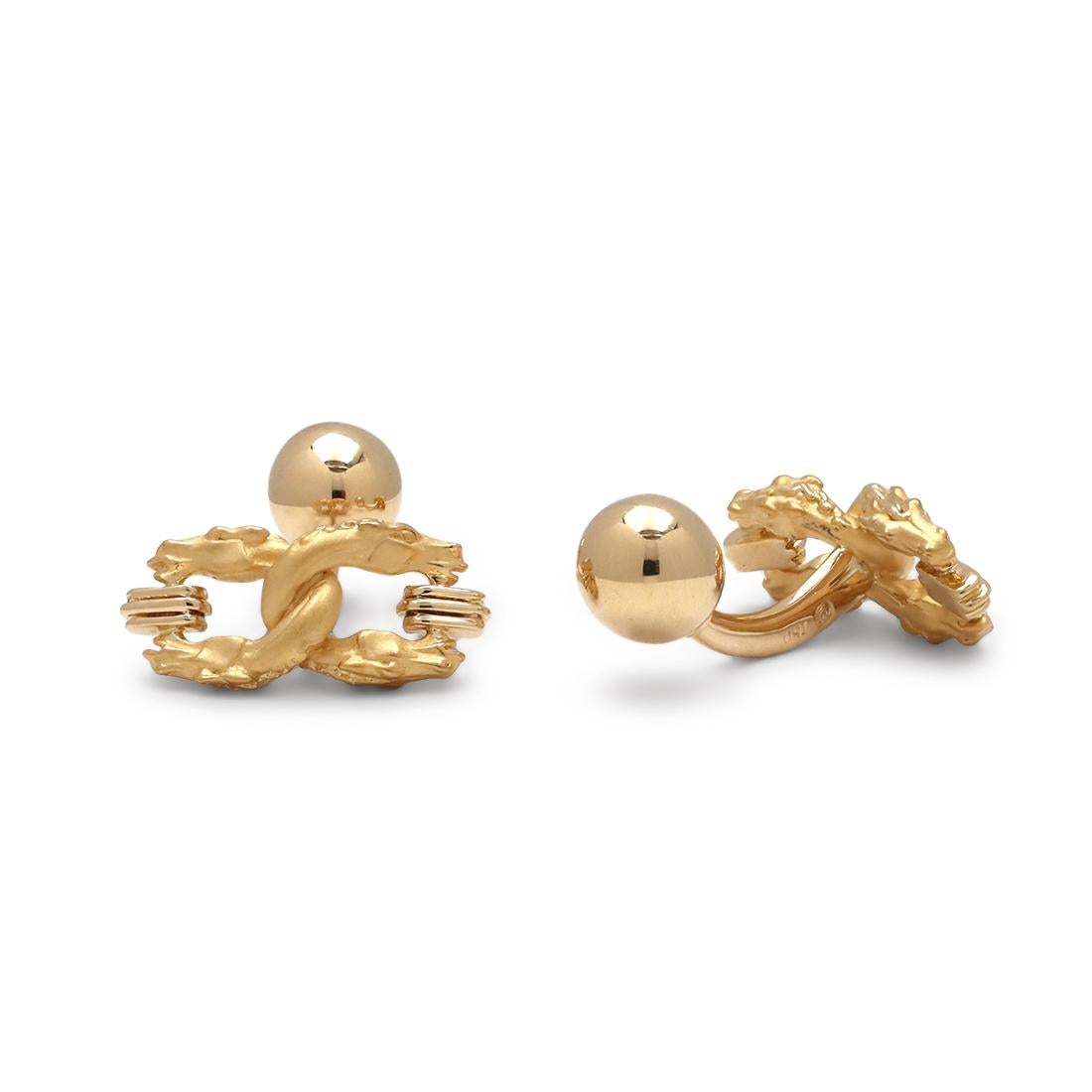 Authentic Carrera Y Carrera cufflinks crafted in 18 karat yellow gold. Each cufflink features 2 interlocking double-headed dragons. The dragon motif measures 17.7mm in length and 8.1mm in width. Signed CyC, 750 with serial number and hallmark. The