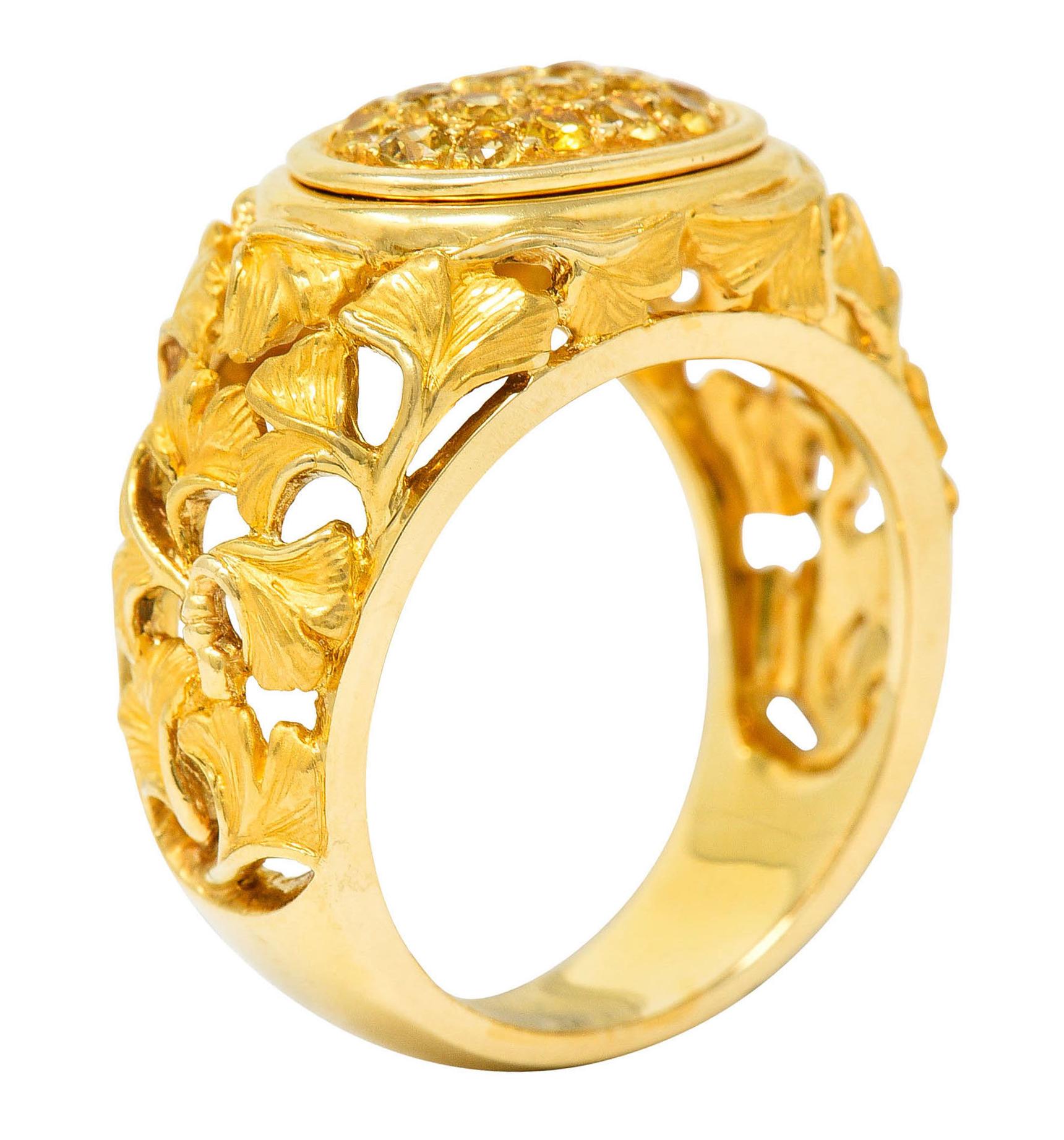 Band ring features a pierced design comprised of highly rendered ginkgo leaves

Centering an oval pavè field of yellow sapphires weighing in total approximately 0.75 carat

Stamped 750 for 18 karat gold with a Spanish assay mark for Madrid

Numbered