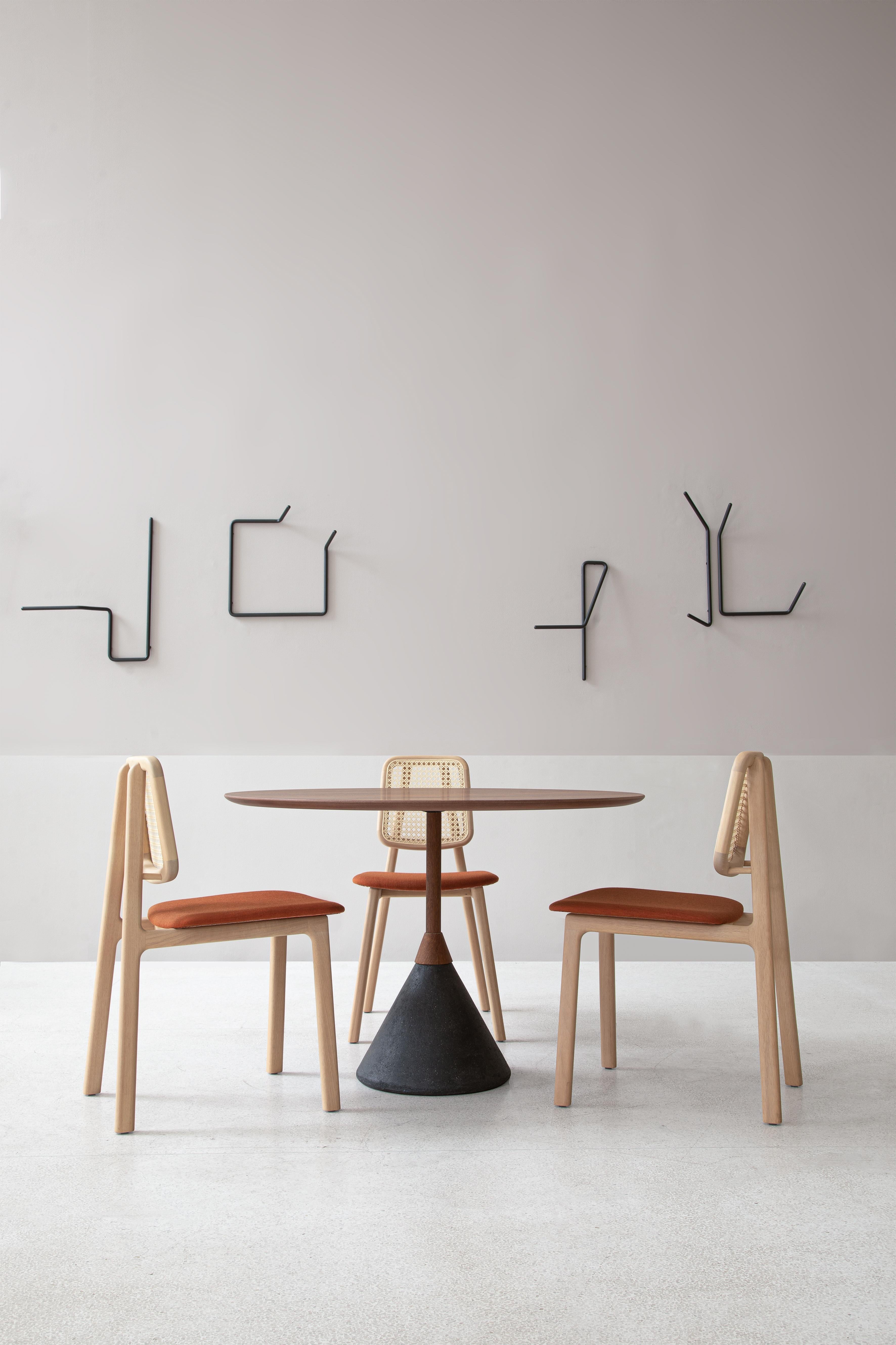 La table Plano, conçue par Steele/One, est un mélange sophistiqué d'acier et de bois indigène brésilien, disponible en Catuaba et Jequitibá. Son design minimaliste s'inspire des structures architecturales, offrant un équilibre saisissant entre force