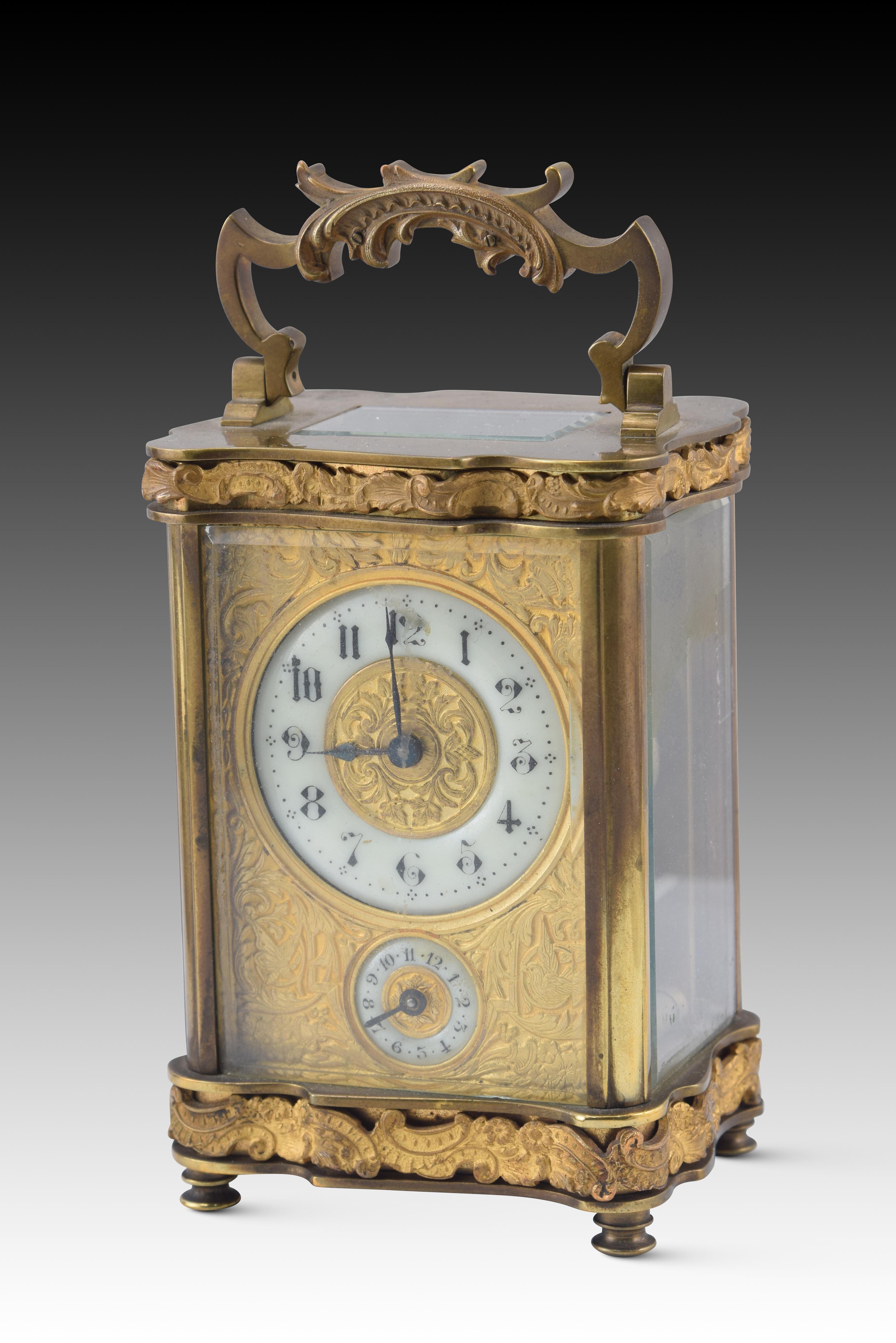 Travel clock with case. Metal, glass, leather, etc. XIX century. 
Case with lid at the top and front with a transparent glass sheet, upholstered on the inside, containing a travel clock with alarm function. It has a handle and decoration in two