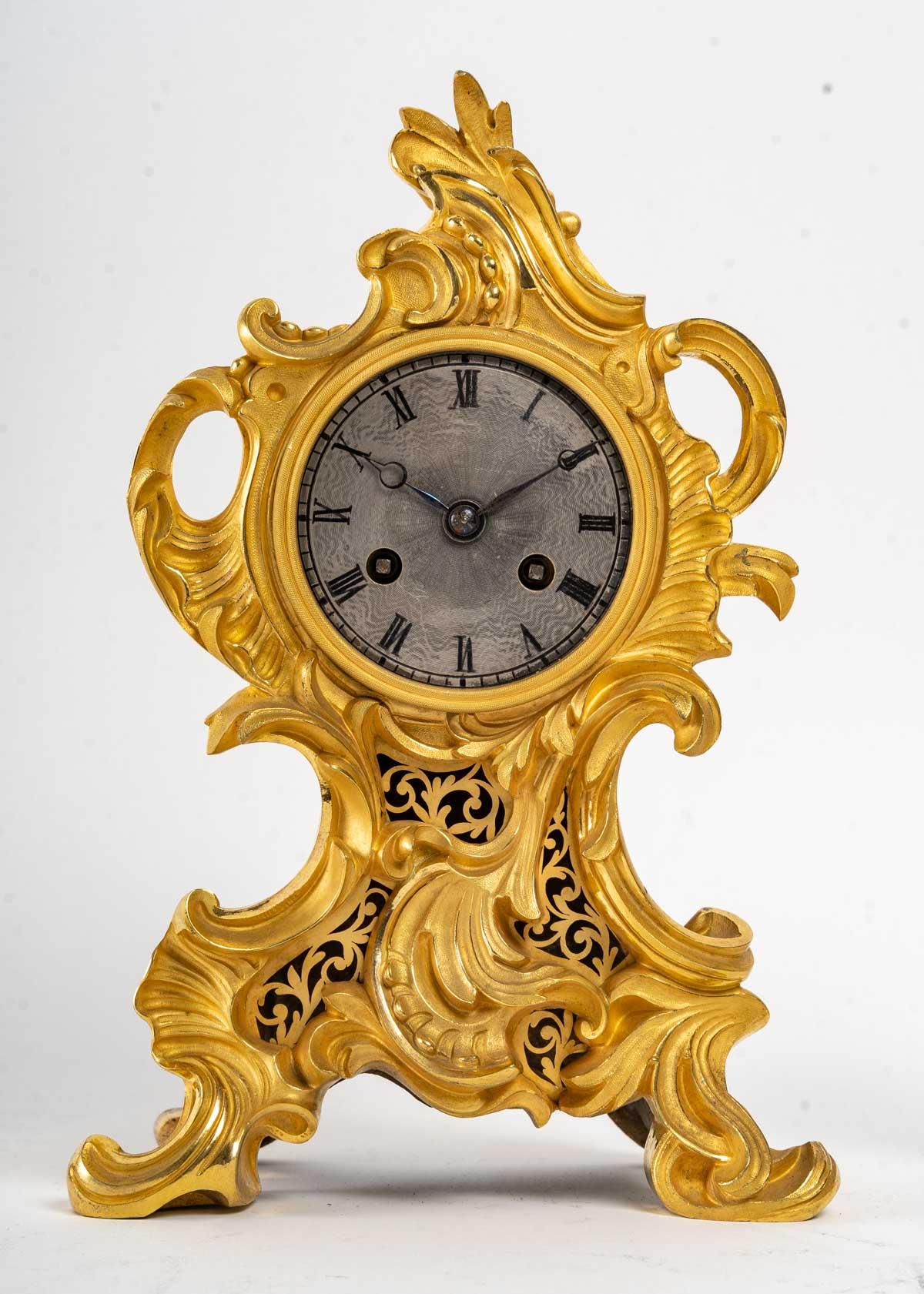 Sublime gilt bronze fireplace trim, finely chiseled and burnished with Agathe.

It consists of a clock resting on four arched feet, with rococo decoration characterized by the fancy of the contoured lines reminiscent of the volutes of seashells