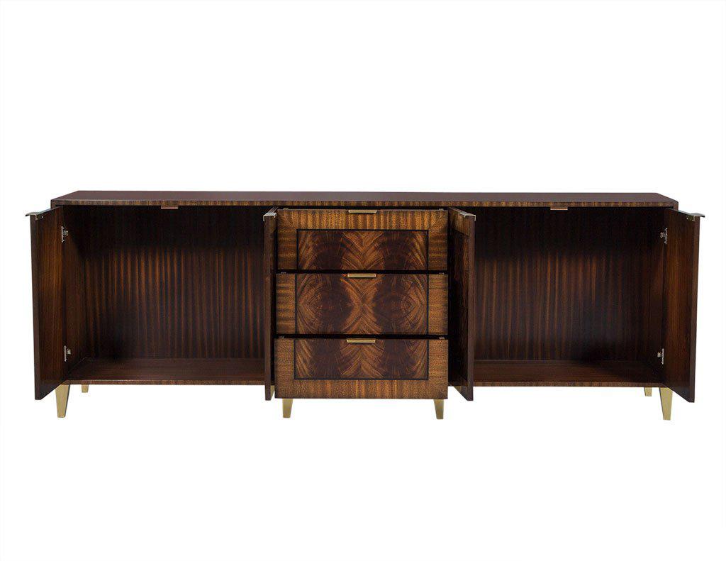 This made to order buffet radiates style and elegance. It is utterly stunning, with doors that have book matched flamed mahogany fields and are bordered with ebony and ribbon mahogany. There are three center drawers at the top that are felt-lined