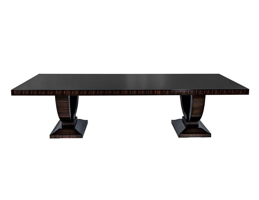 Stunning Carrocel Custom Collection dining table in exotic Macassar ebony veneer features a solid one-piece top that can be expanded with extension leaves on both ends. This top is resting on double ‘U’ pedestal each with sloped block-layered plinth