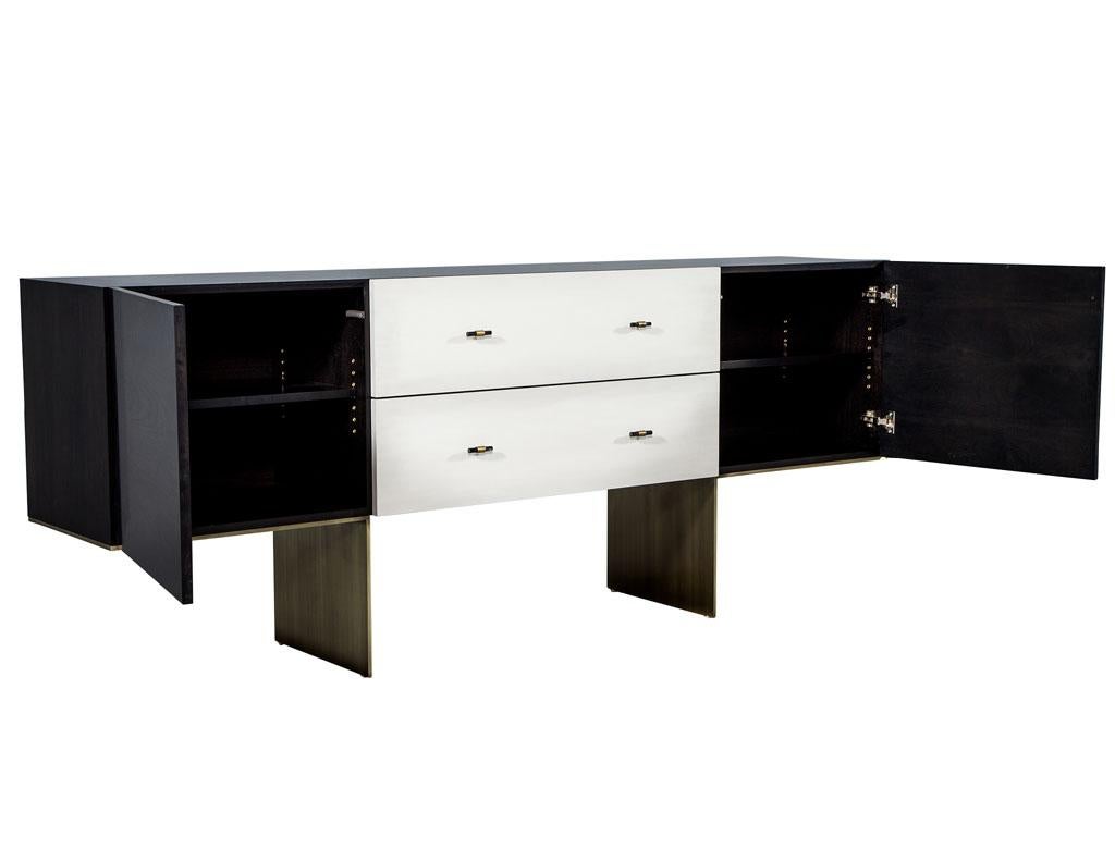 Buffet moderne sur mesure en Macassar Carrocel Credenza. Buffet en Macassar fait sur mesure, en Macassar poli à la main, accentué par des tiroirs finis en parchemin et ornés de poignées en or, perché sur une base solide en laiton patiné.