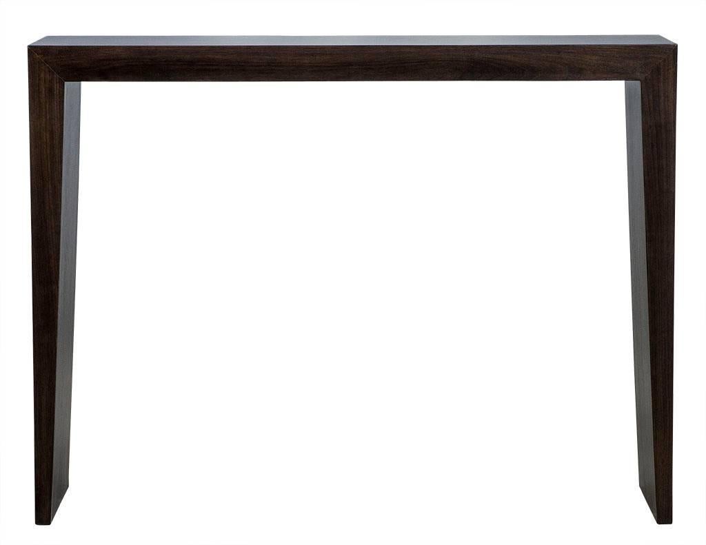 This console table and stool set is made to order. Crafted out of solid walnut, the table and two matching stools/benches have flared sides giving each a distinctive edge. The set is finished in a hand-polished rich tobacco brown and is a perfect