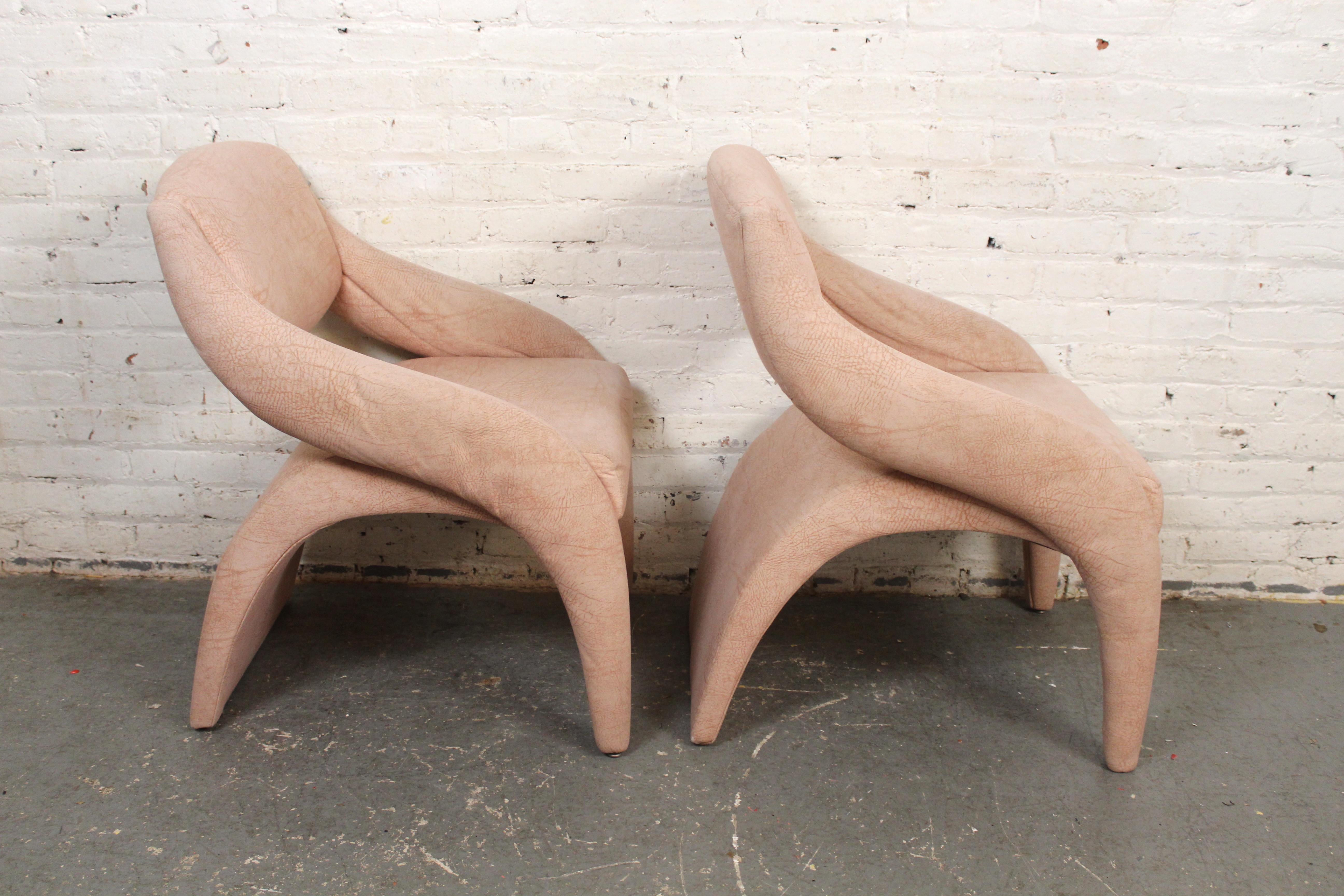 Unique mid-century style faux leather chairs. Sculpted frames in soft pink fabric. 
Please confirm location NY or NJ