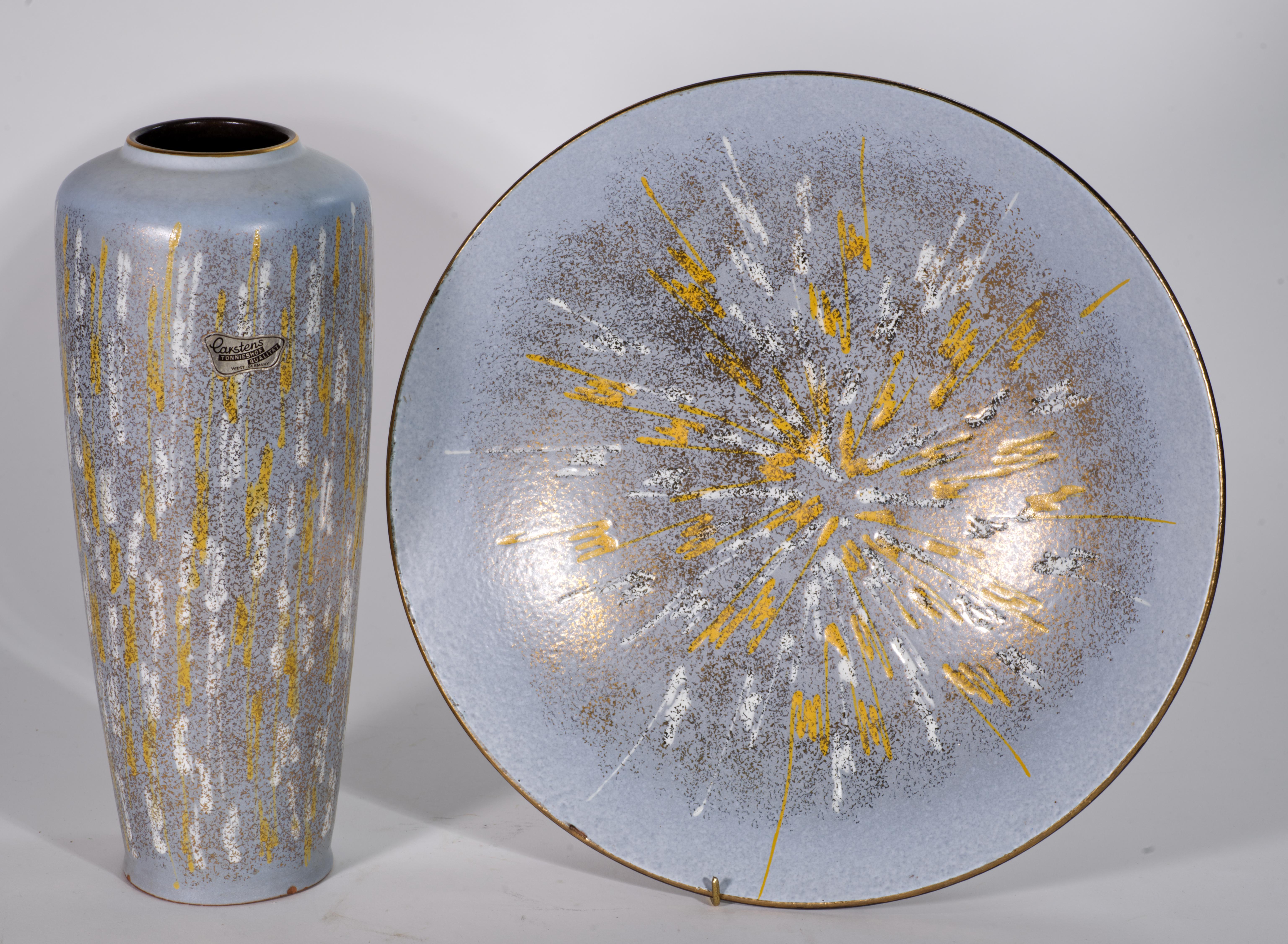 
Set of a large bowl and cylindrical vase was made by Carstens Tönnieshof with complex, textured lava white and buttery yellow glazes on light grey glaze background with gold accents throughout. The bowl has monochromatic black glaze on the bottom