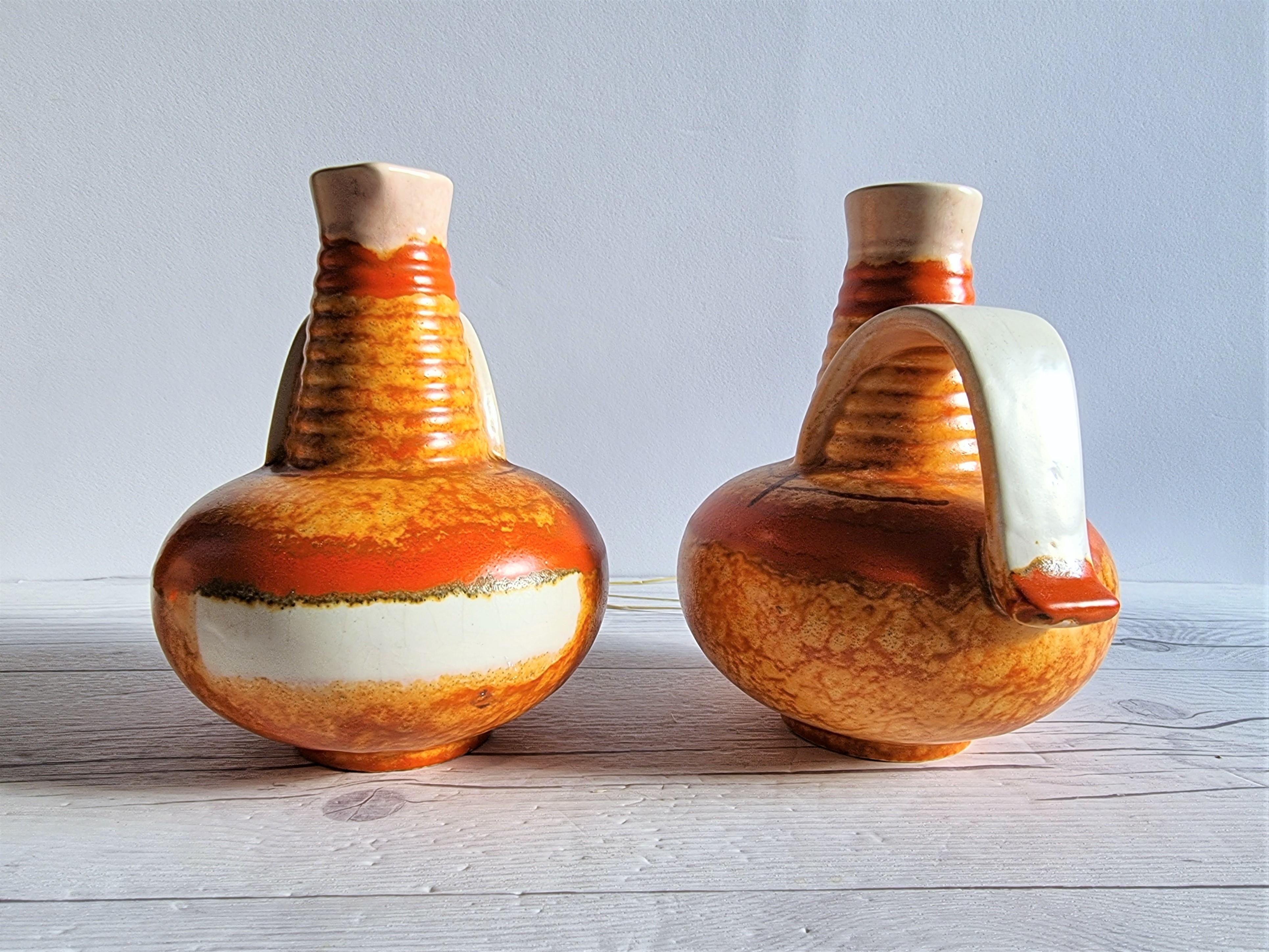 This stunning duo of 1930s Bauhaus Art Deco design is by Carstens Uffrecht Pottery and attributed to the lead designer Hildegard Delius (b. 1896 - d. 1955). 
The forms of the vases physically displays the geometric Bauhaus influence throughout,